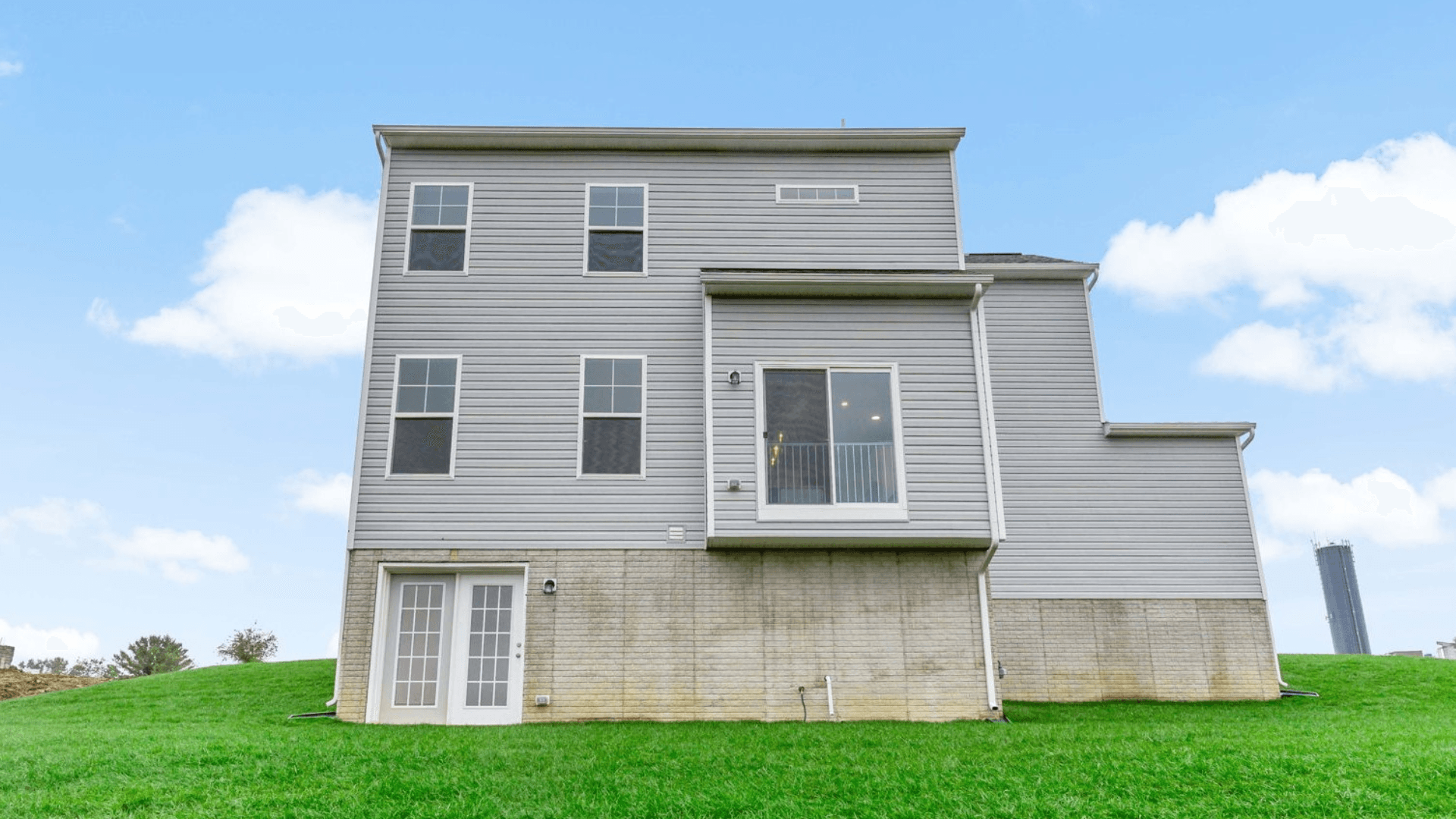 The back exterior of the Newbury features abundant windows and showcases the outdoor space.
