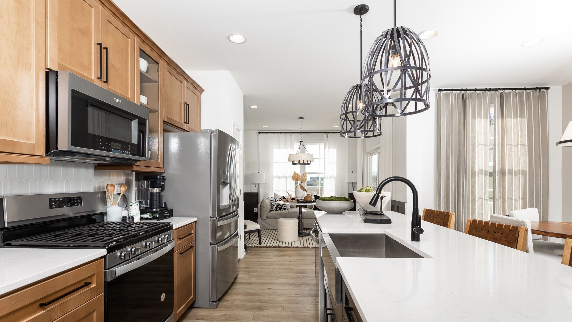 Spacious kitchen with natural wood cabinetry, modern appliances, and honey oak floors.