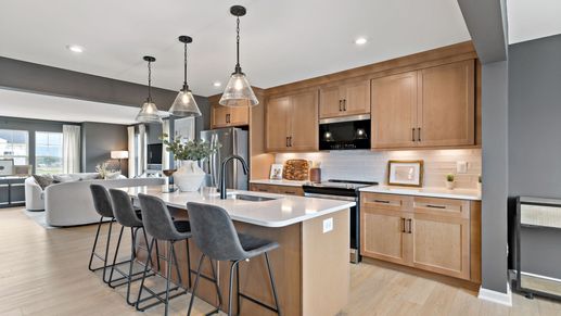 Kitchen with stainless steel appliances, pendant lights, and an island in the York II Garage at The Gallery.