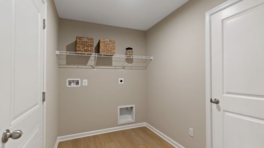 Efficient laundry room with shelving and space for washer/dryer in the Edgewood II floor plan.