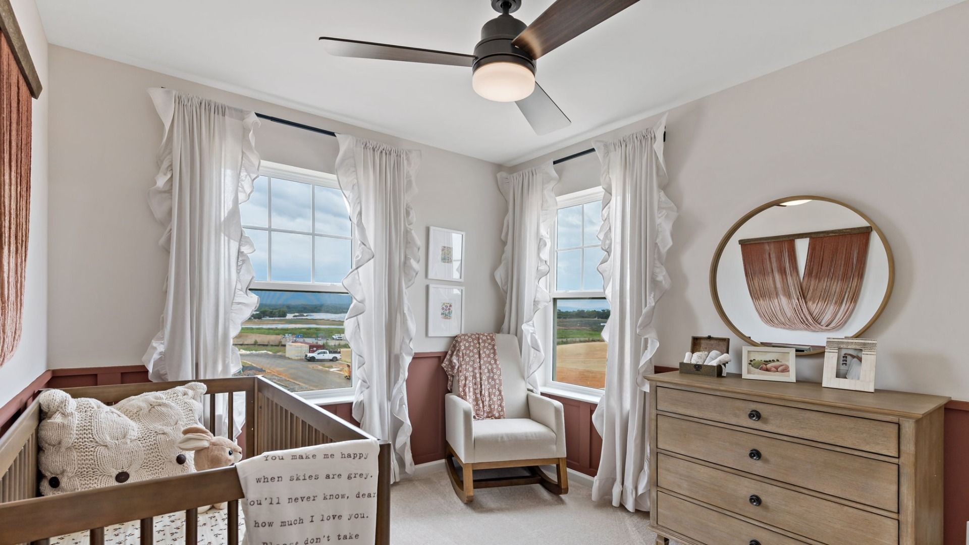 Secondary bedroom with a crib, dresser, and large windows offering a construction view from the York II Garage floor plan.