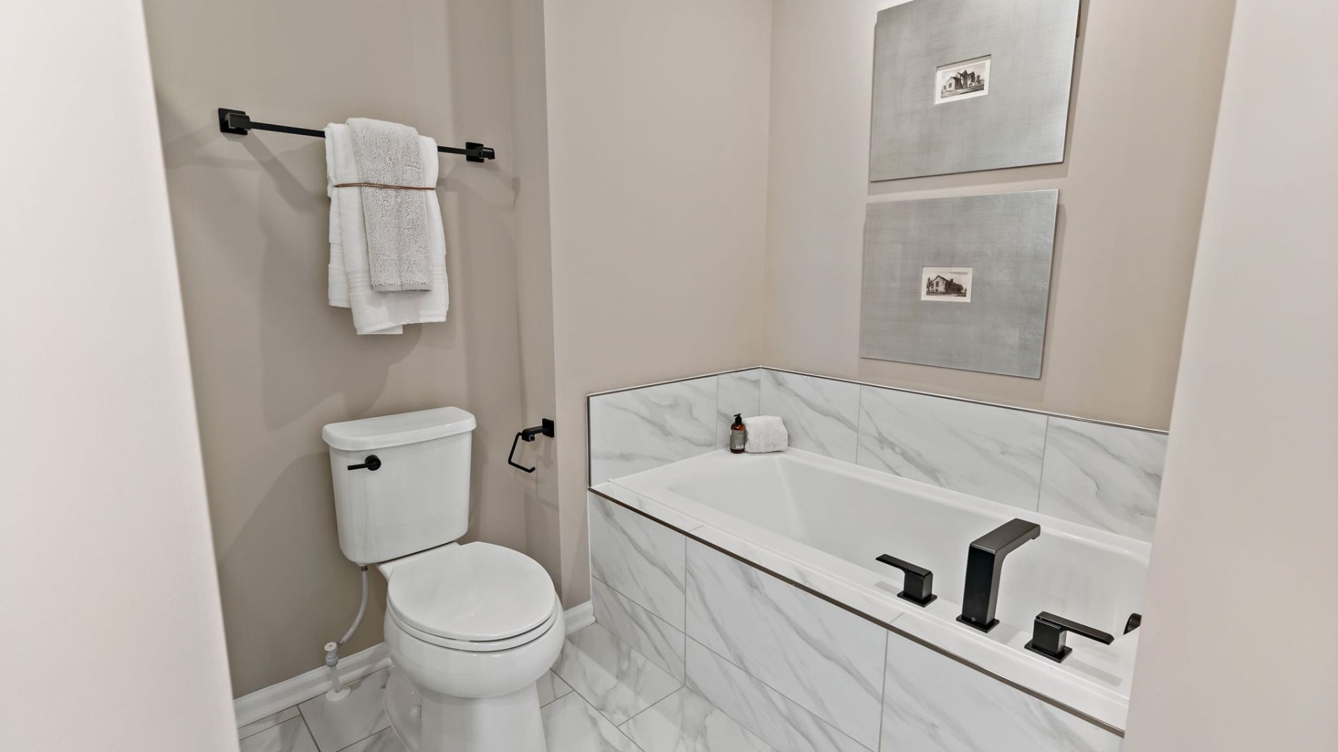 Bathroom featuring a tub, white towels, and framed artwork in the York II Garage floor plan at The Gallery, Martinsburg, WV.