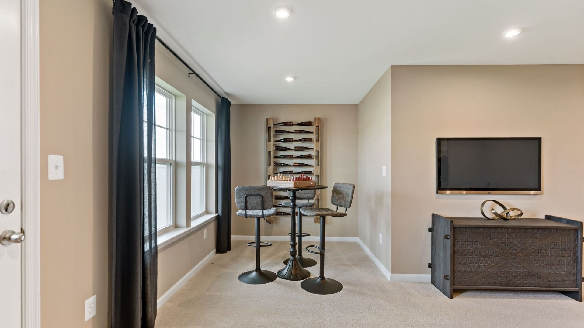 A cozy flex room in the York II Garage floor, perfect for personalization with a wine rack and TV.