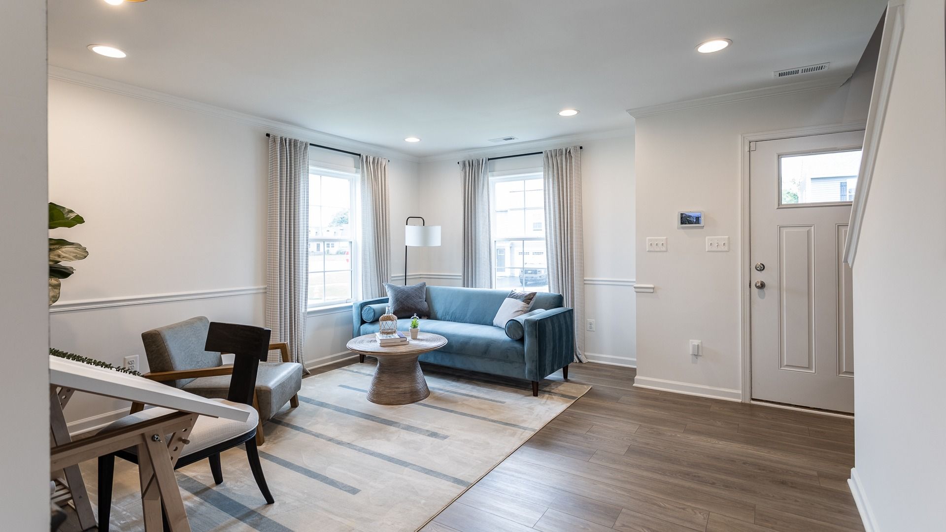 Spacious living room in the Carnegie II floor plan with wood floors and abundant natural light.