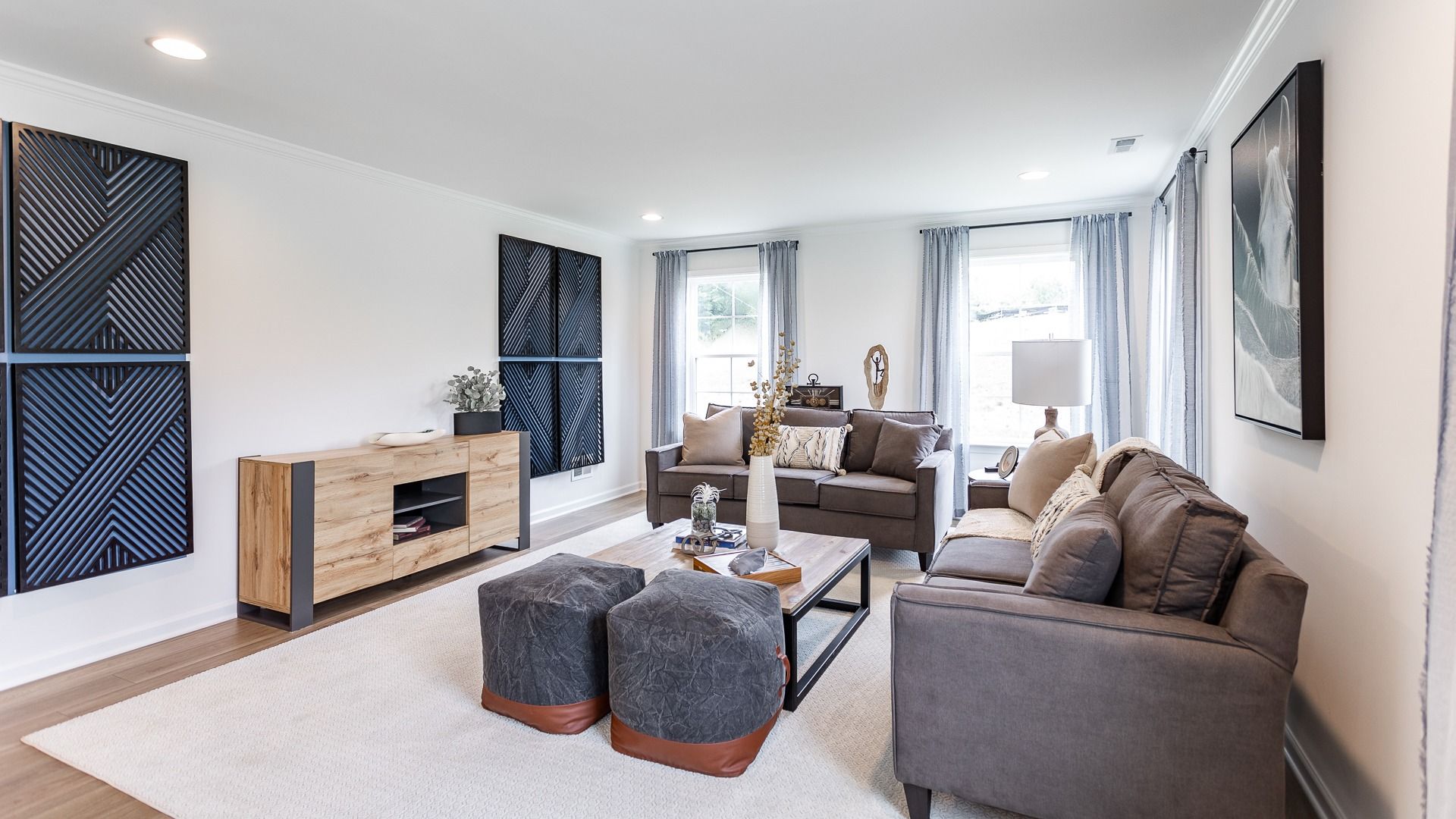 The living room in the Carnegie II is spacious, with large windows that bring in natural light.