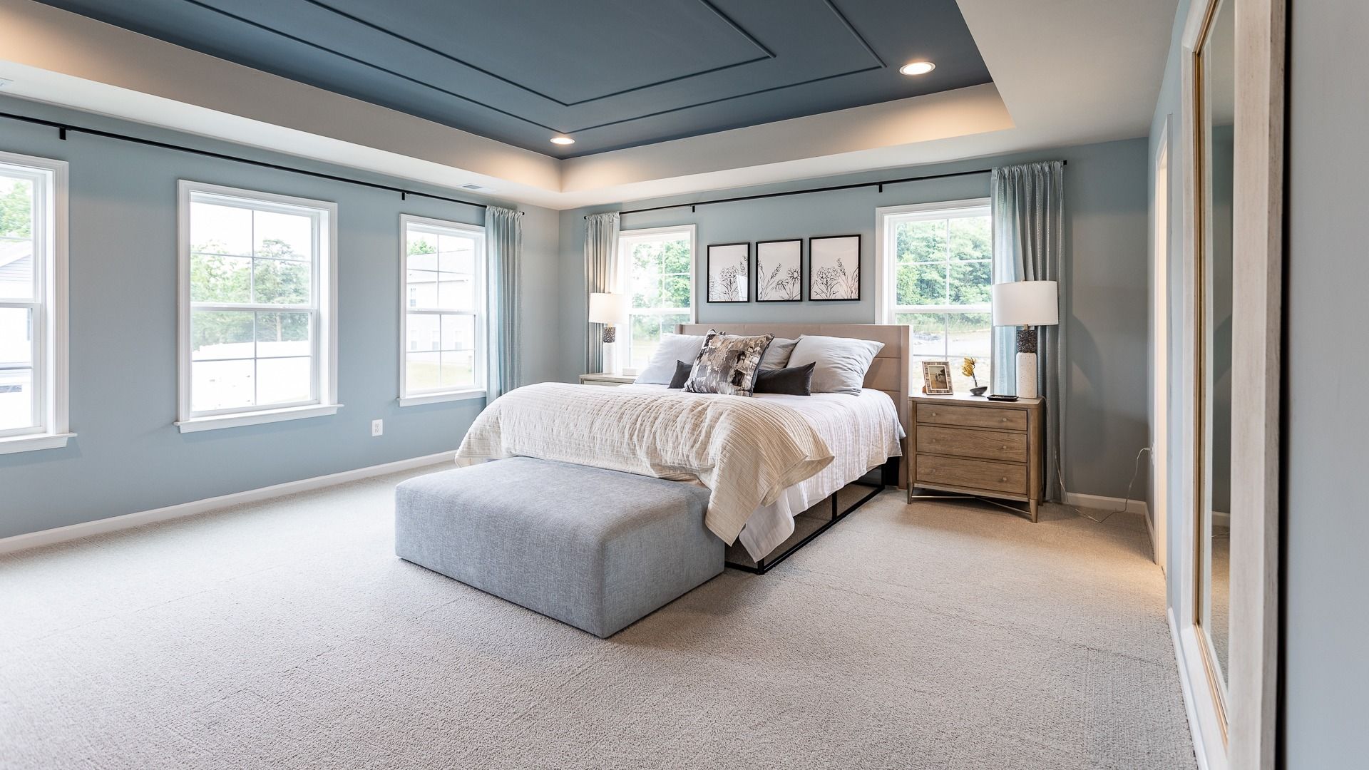 Enjoy the primary suite in the Carnegie II, a relaxing retreat with a tray ceiling and large windows.