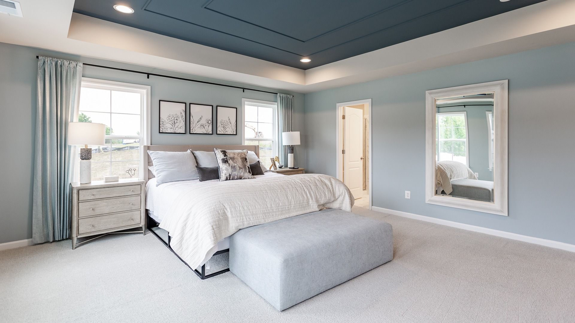 A serene bedroom in the Carnegie II offers an open, airy space filled with natural light.