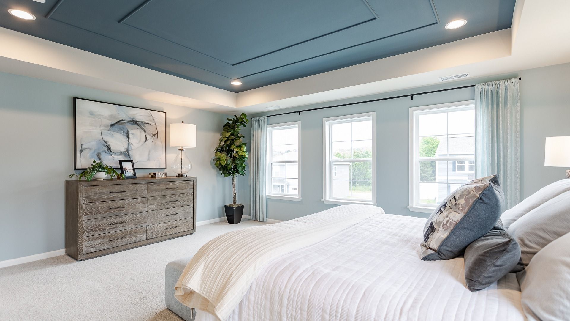 Subtle rustic accents and large windows make the primary bedroom in the Carnegie II bright and inviting.