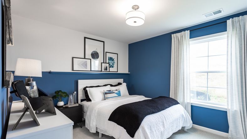 Stylish bedroom in the Carnegie II floor plan features soft natural light creating a cozy atmosphere.