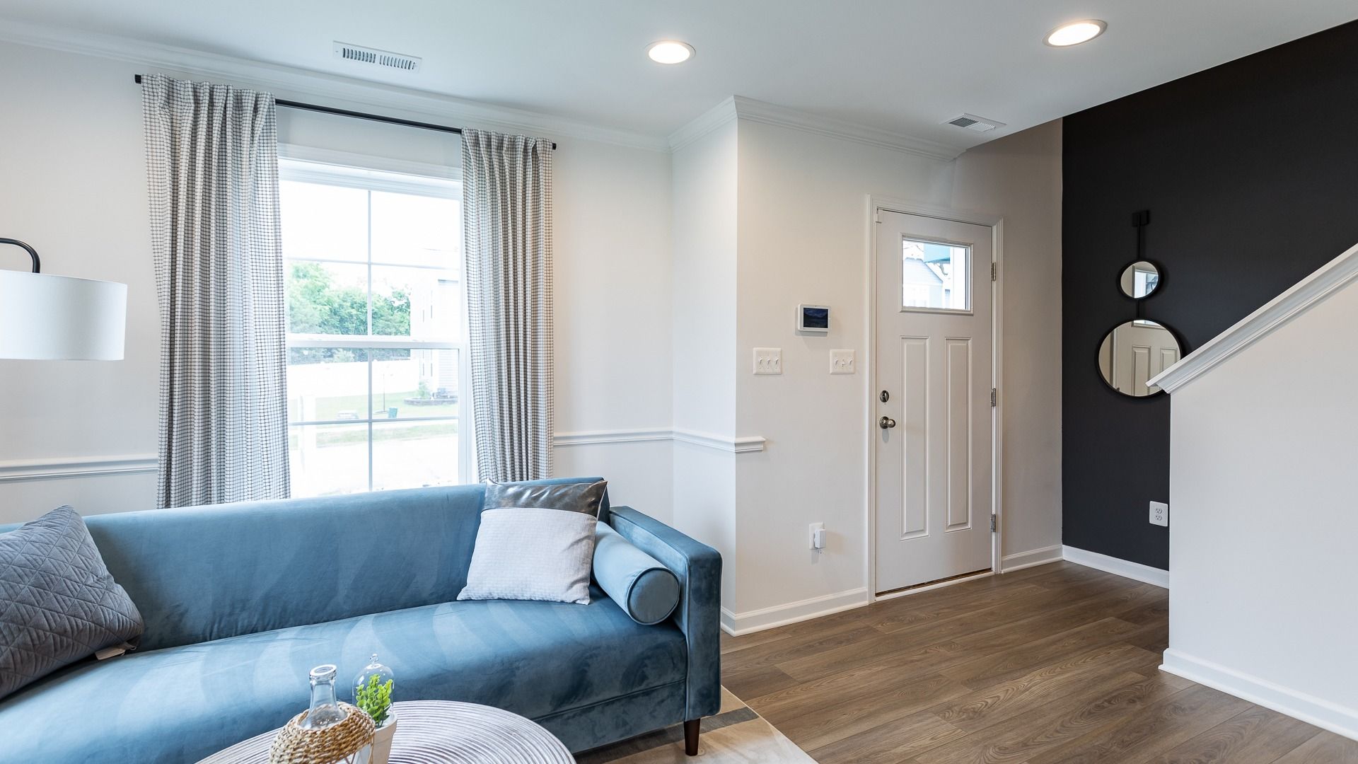 Cozy living area in the Carnegie II floor plan with a large window and stylish accents.