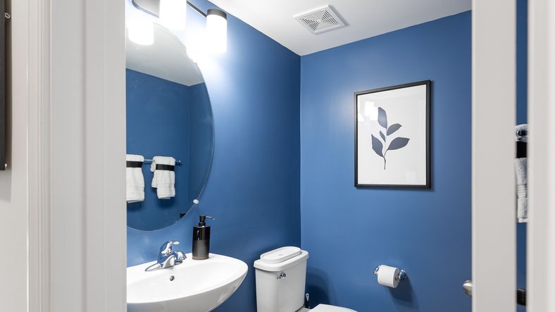 A stylish powder room in the Carnegie II floor plan with pedestal sink and mirror.