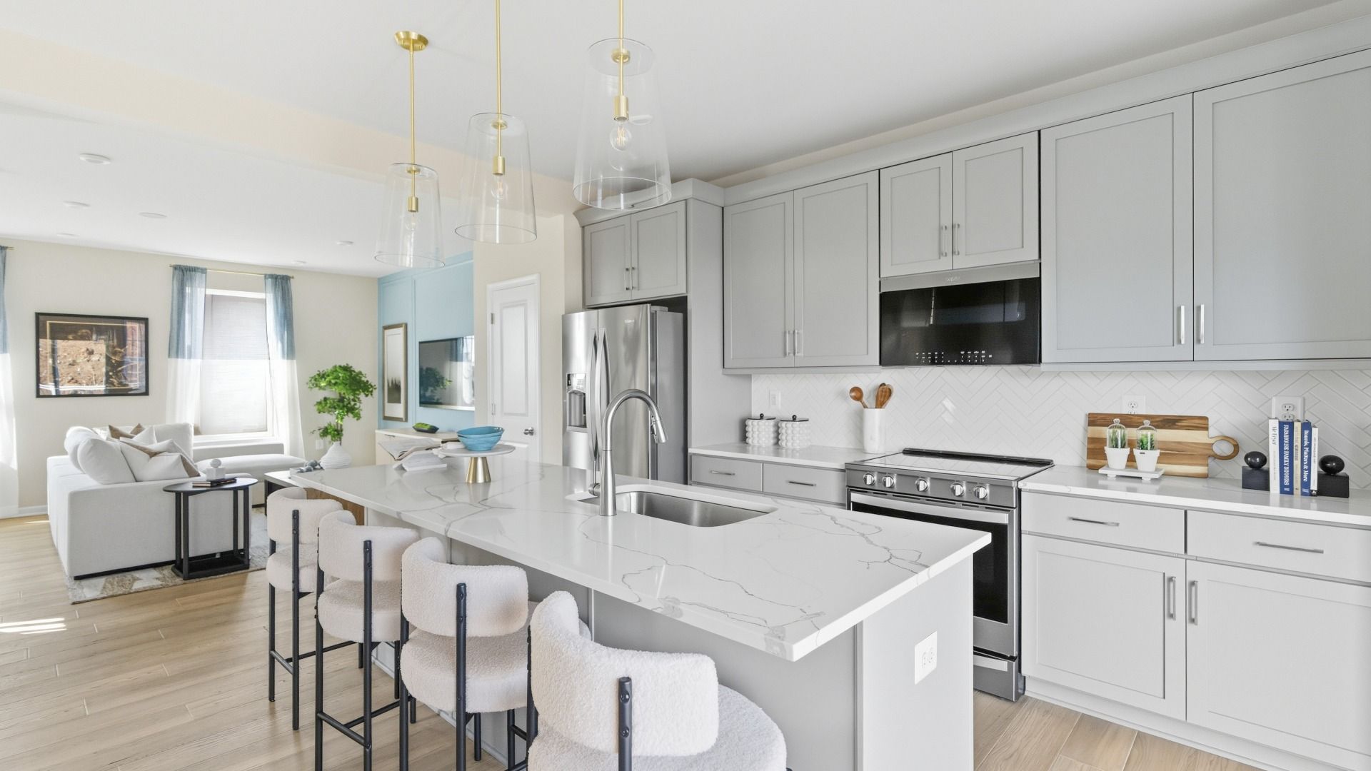 Bright kitchen and living room in the Bedford II featuring a spacious layout and large center island.