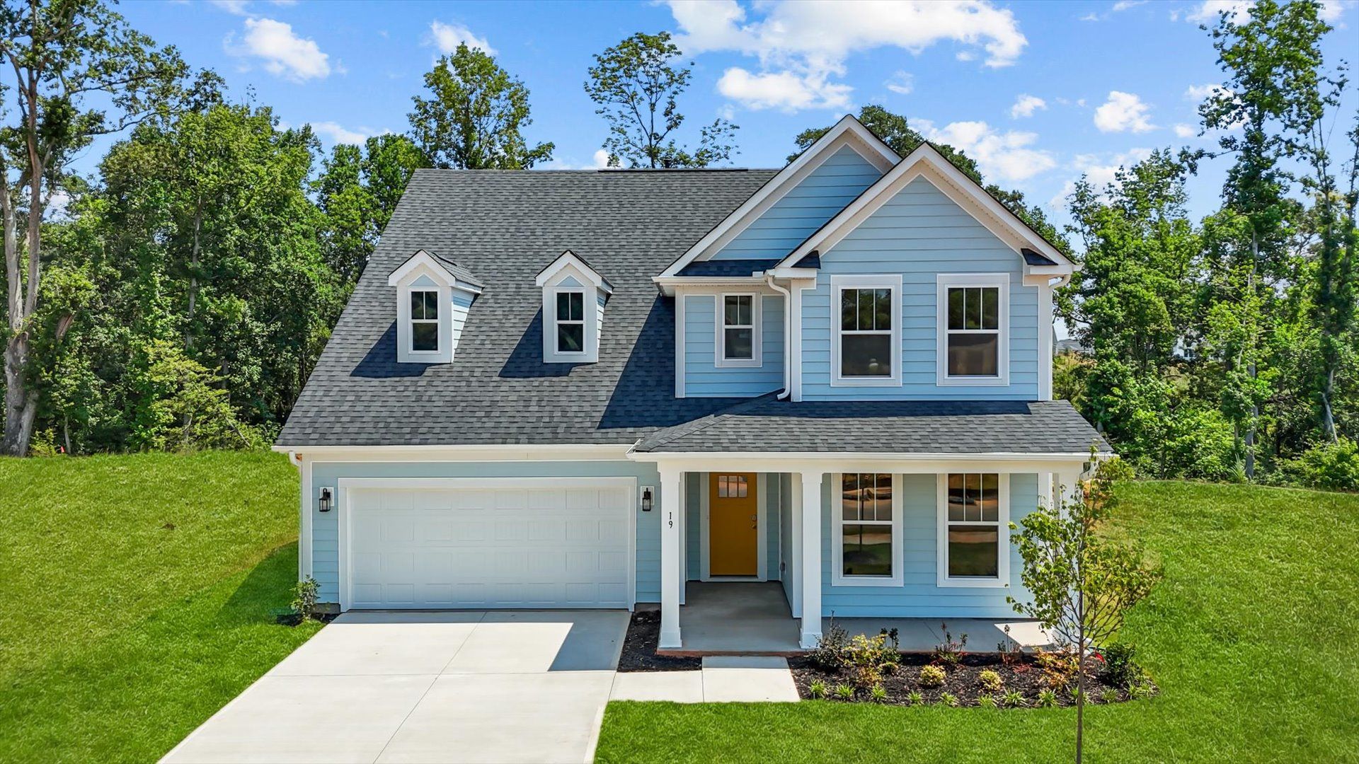 Stunning light gray exterior two story home with two car garage and large windows at Pelham Crossing by DRB Homes