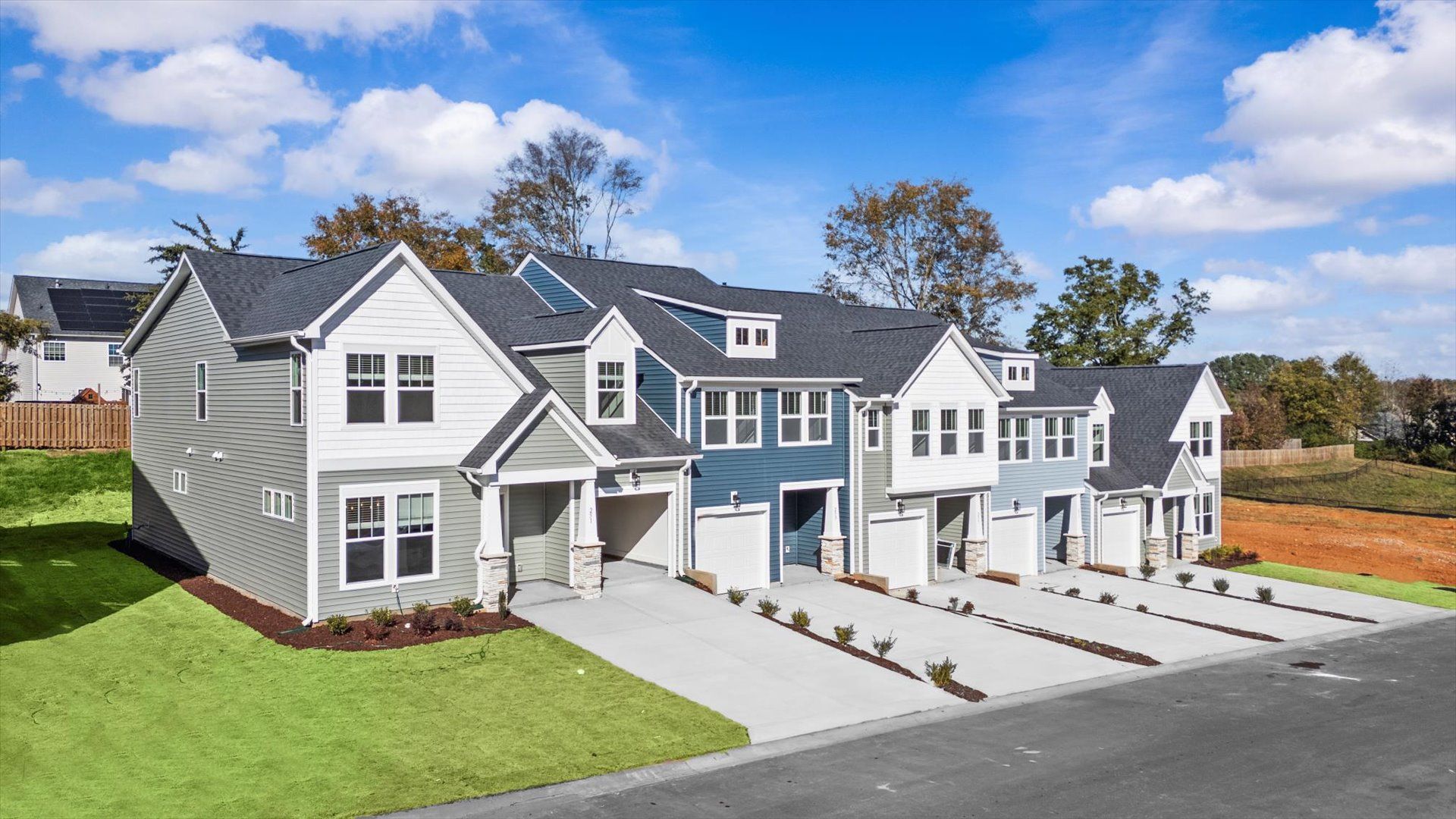 Two story townhome with two car driveway, one car garage, and large windows with light blue exterior at Aspen Ridge