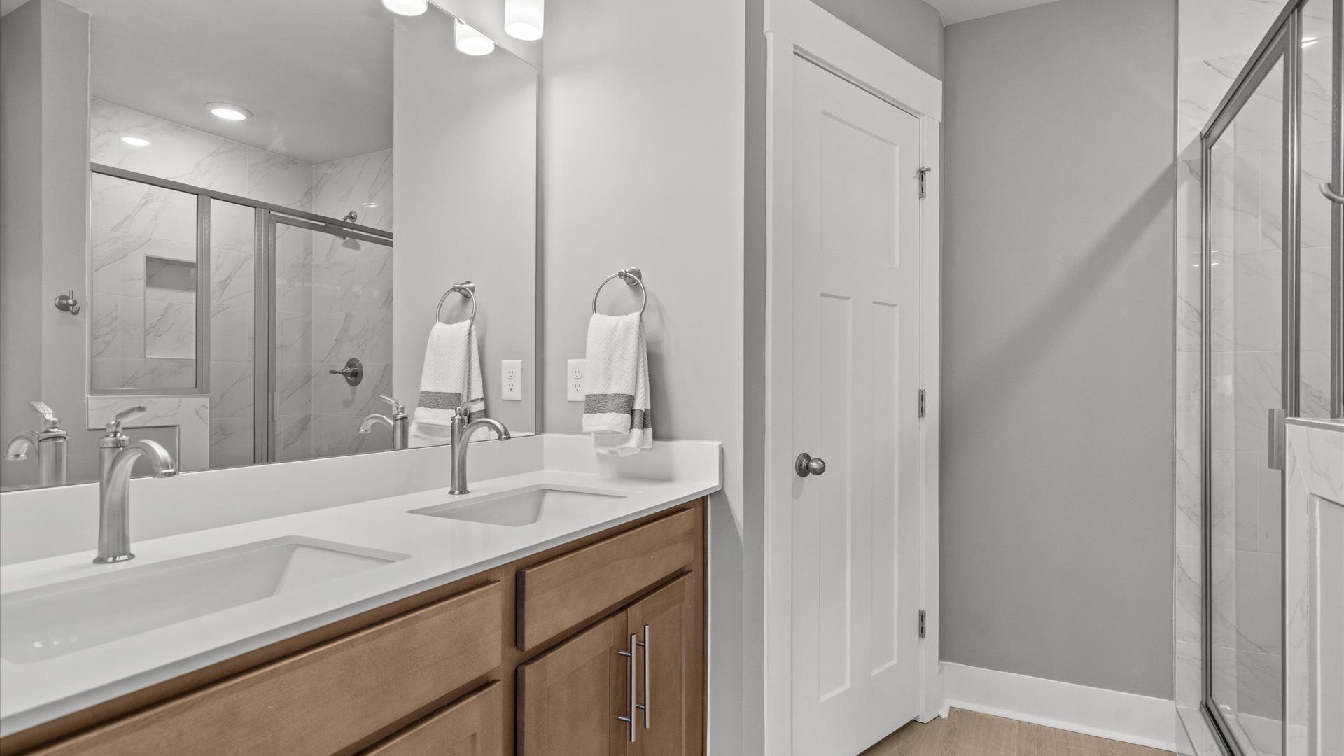 Elegant primary bathroom featuring a spacious walk-in shower and dual vanity in this first-class DRB design at El Dorado