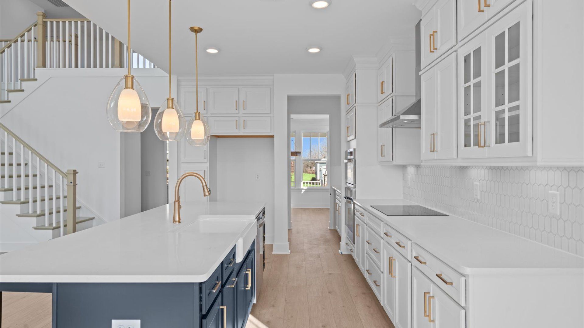 Tasteful kitchen with oversized island and stylish pendant lighting crafted to high standards