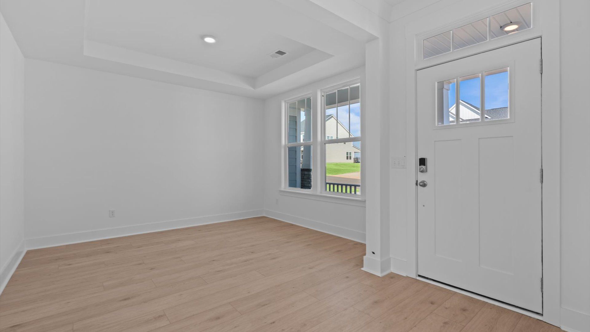 Tasteful living room with tray ceiling, modern fixtures, and a warm, inviting feel