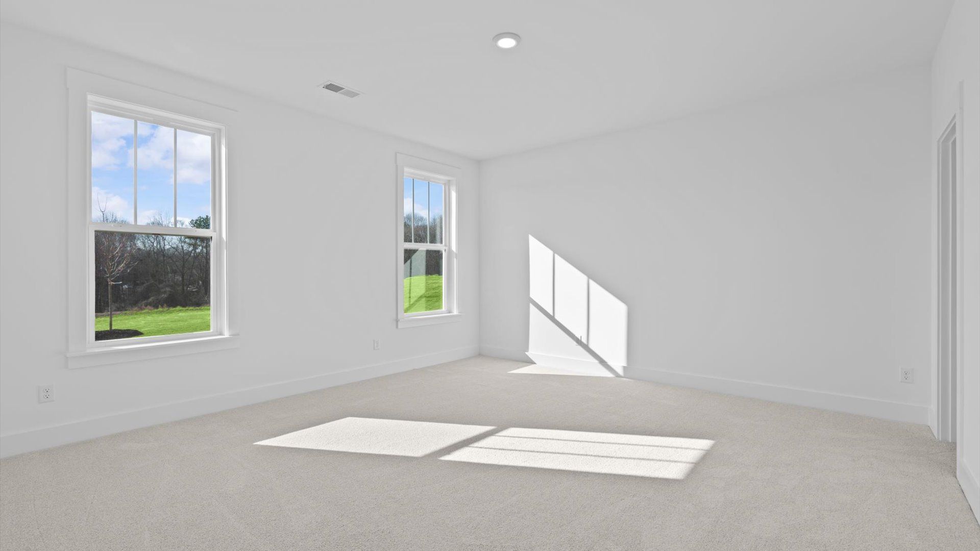 Superior comfort in this light-filled bedroom with plush carpeting and thoughtfully placed large windows