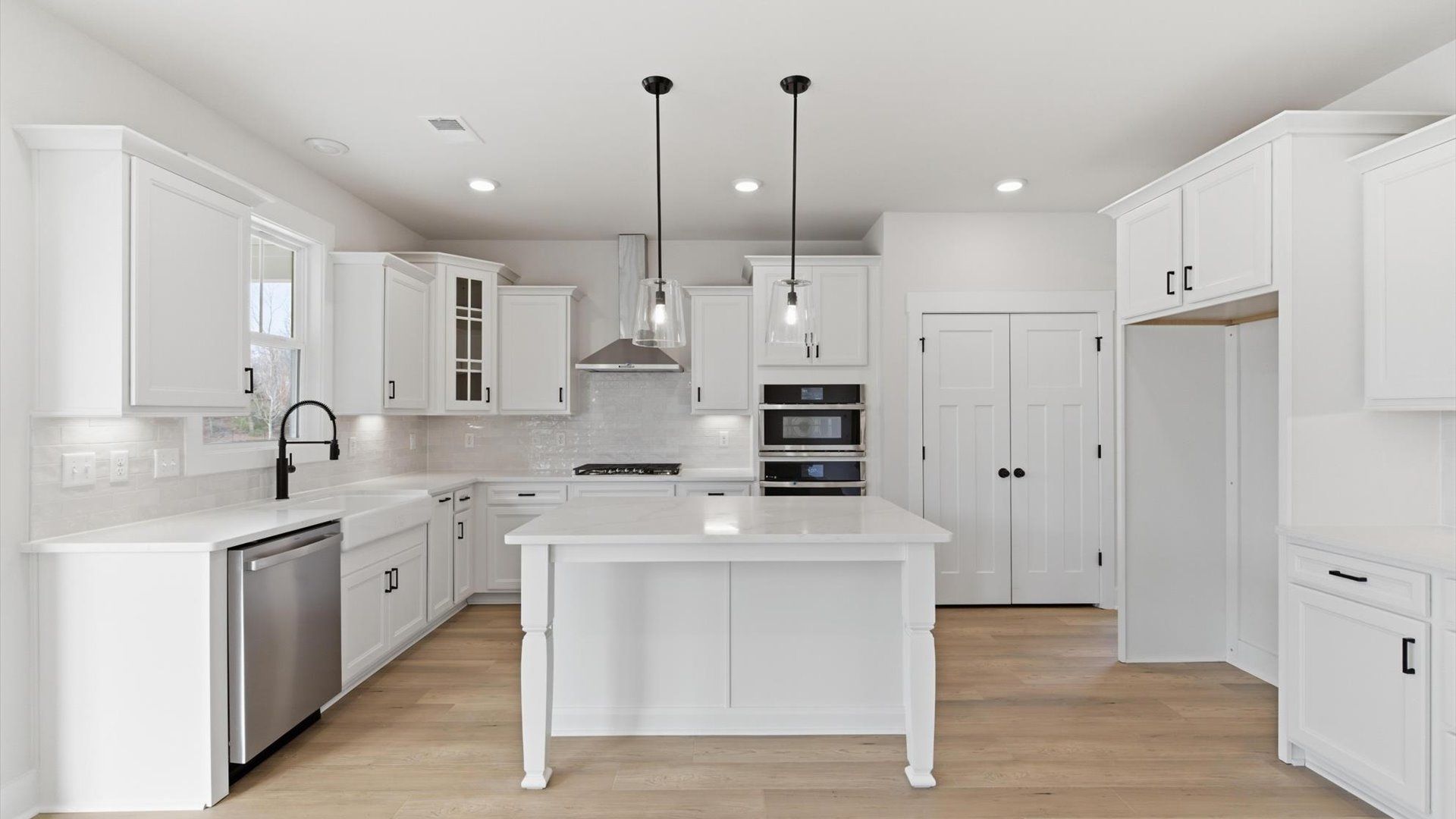 Superior kitchen with quartz countertops, pendant lighting, and a generously sized island located at Pelham Crossing