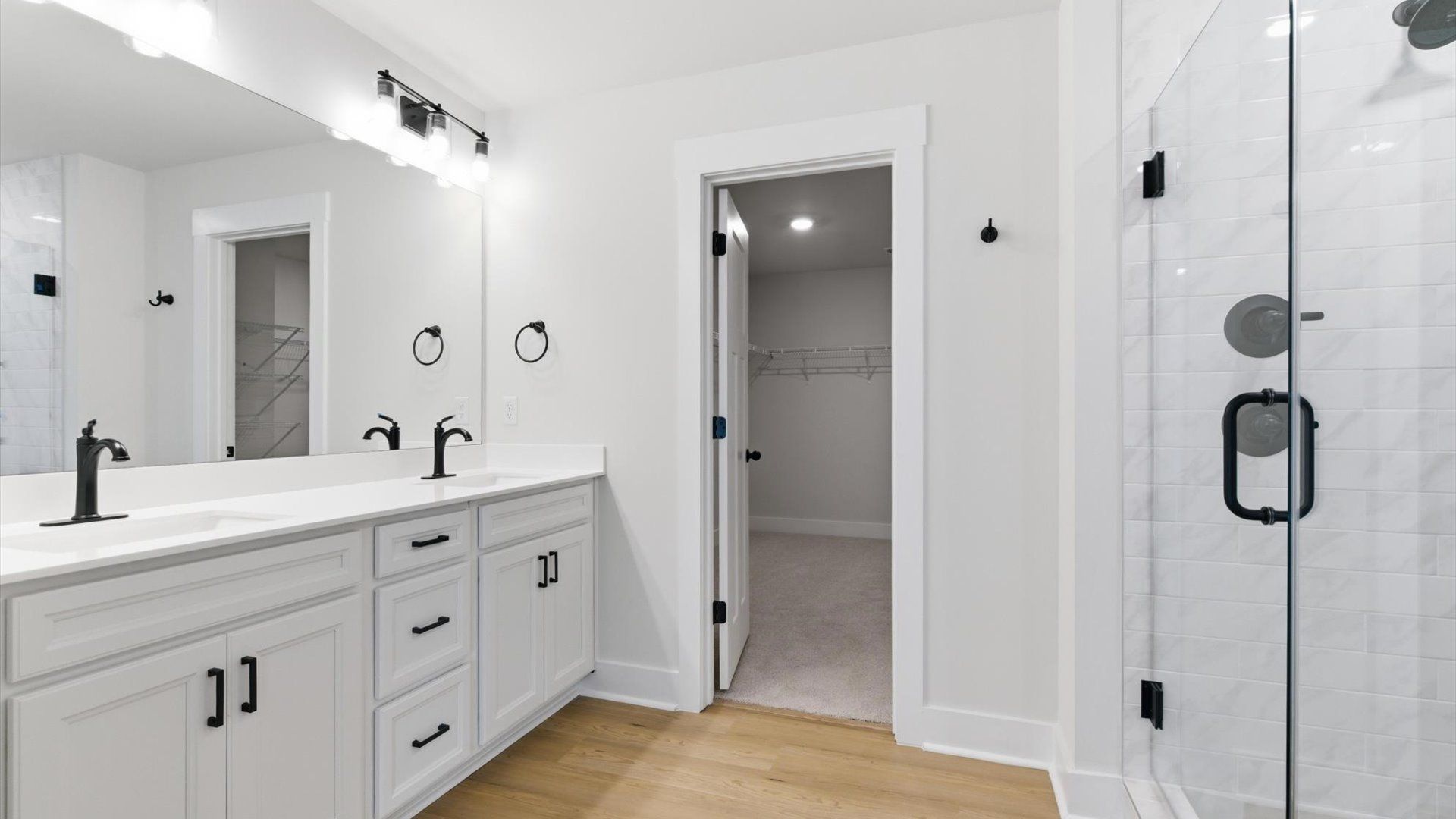 Superior en-suite primary bathroom with stylish dual vanity and walk-in shower—crafted with high standards in mind