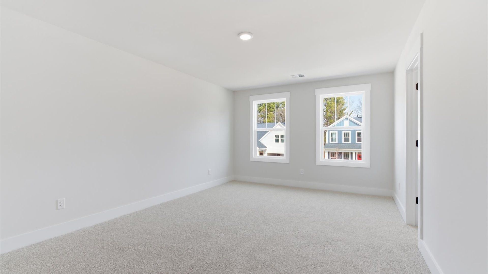 Superior comfort in this light-filled bedroom with plush carpeting and thoughtfully placed large windows in Greenville, SC