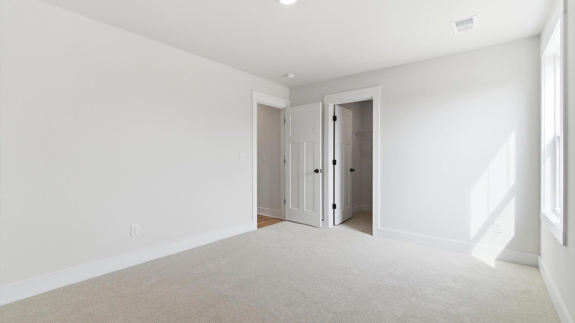 Highly functional bedroom with a large window, carpeted flooring, and tasteful finishes throughout located in Greenville, SC