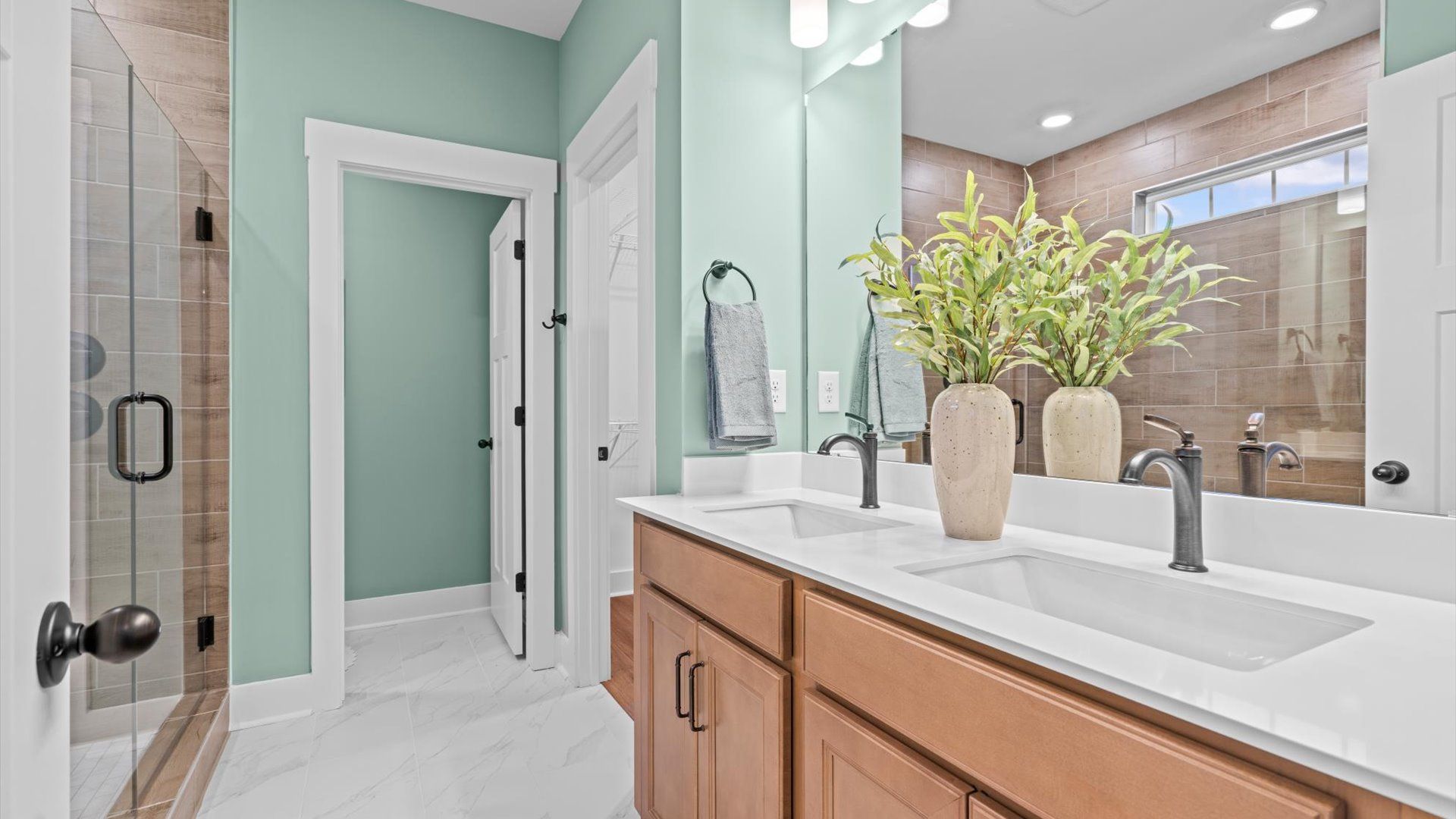 Superior en-suite primary bathroom with stylish dual vanity and walk-in shower—crafted with high standards in mind