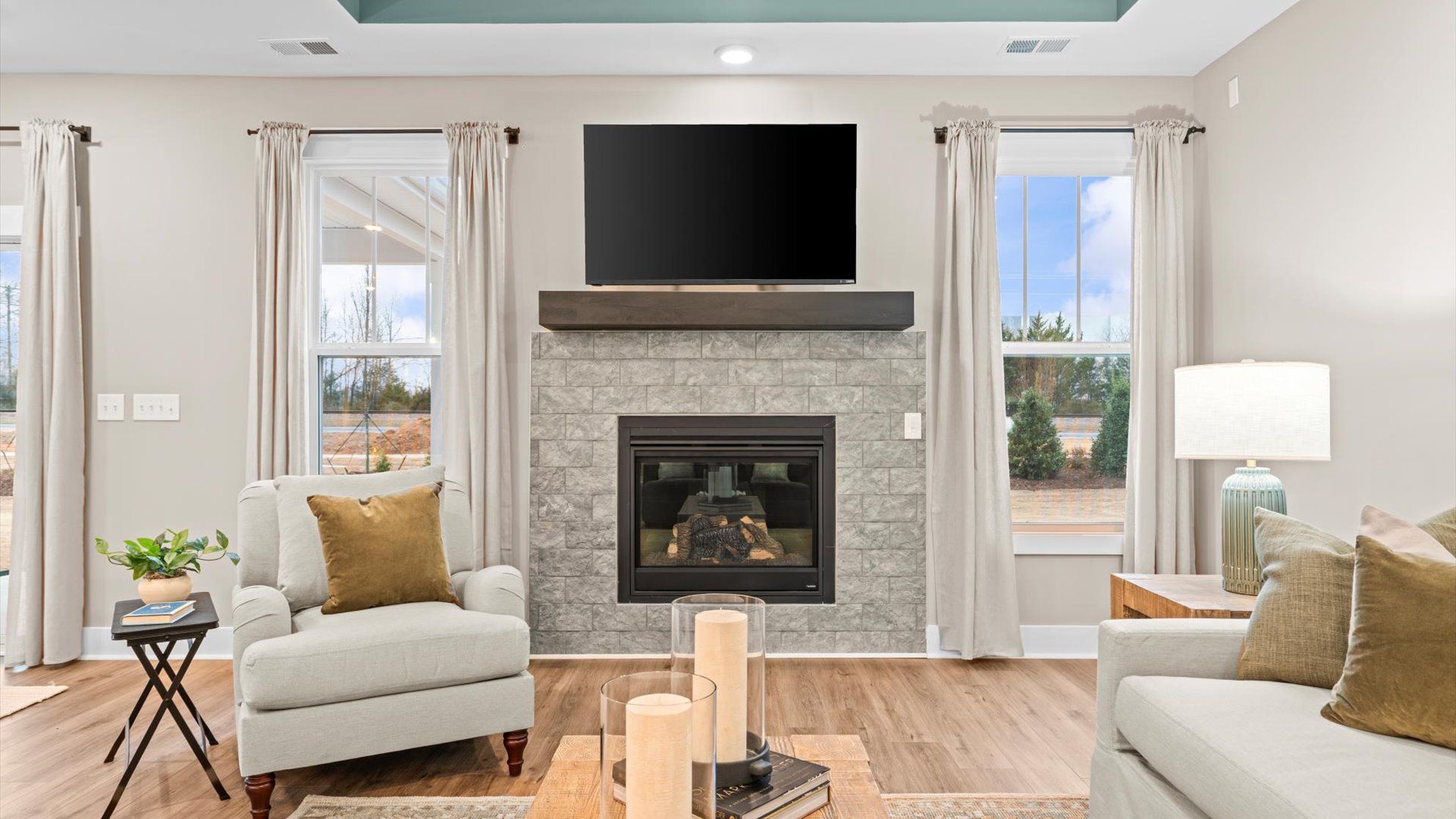 Elegant family room featuring hardwood flooring, large windows, and thoughtful architectural detail