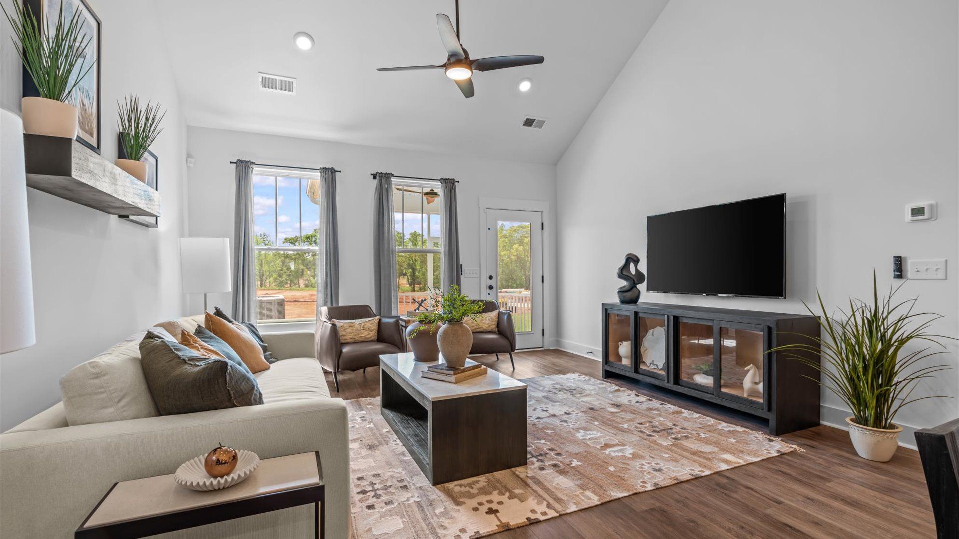 Tasteful family room with two-story volume, refined finishes, and exceptional natural light at the Robert's Farm community