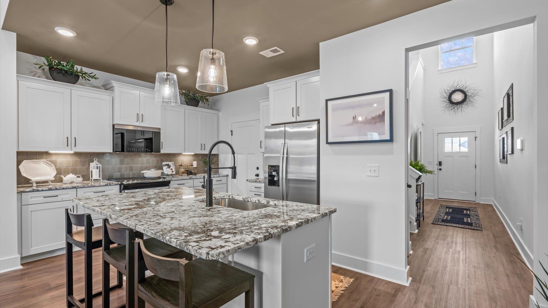 Superior kitchen with quartz countertops, pendant lighting, and a generously sized island at the new Robert's Farm community