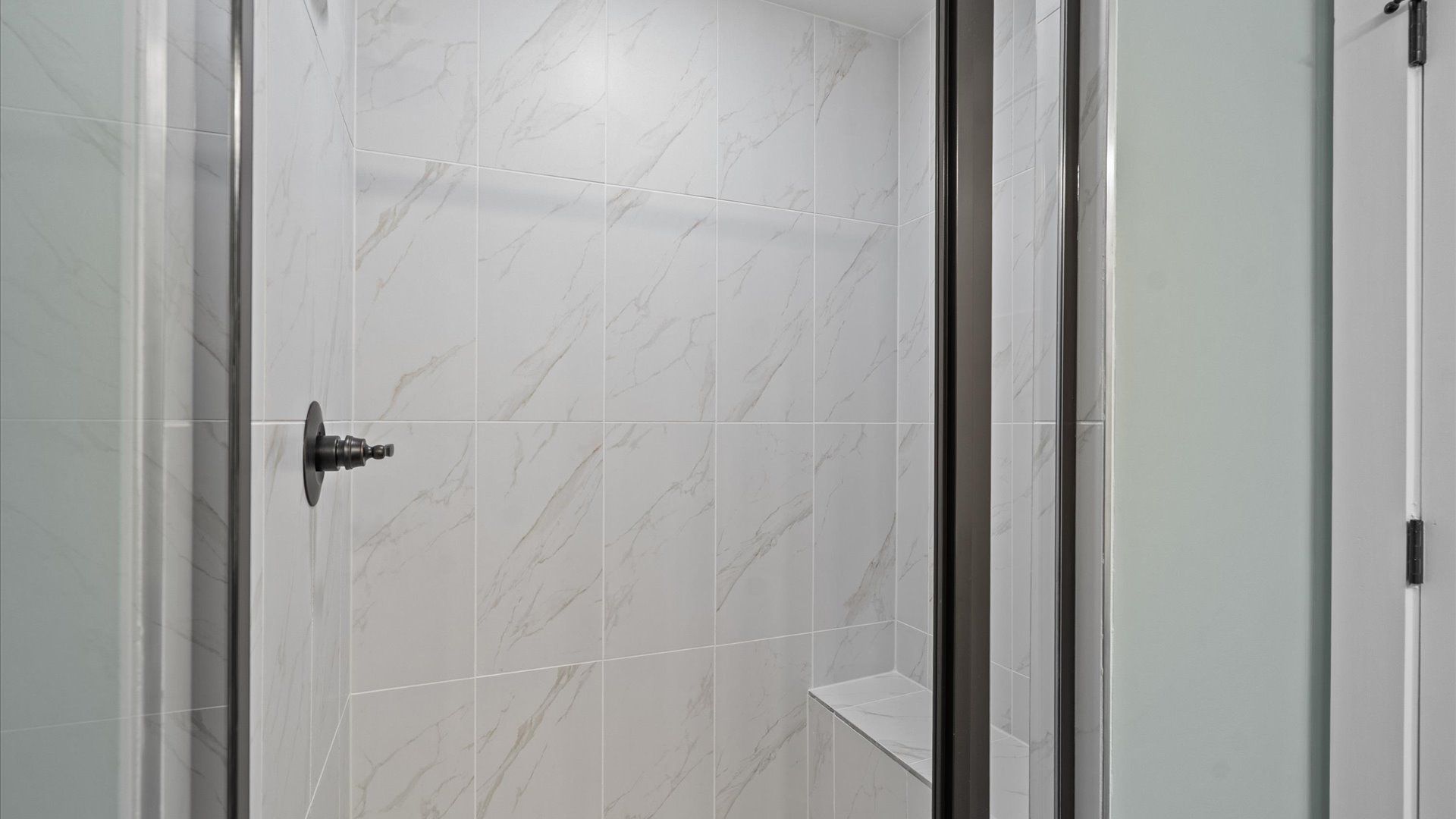 Memorable mornings begin in this elegant primary bathroom with a tiled walk-in shower at the new Anna's Pointe community