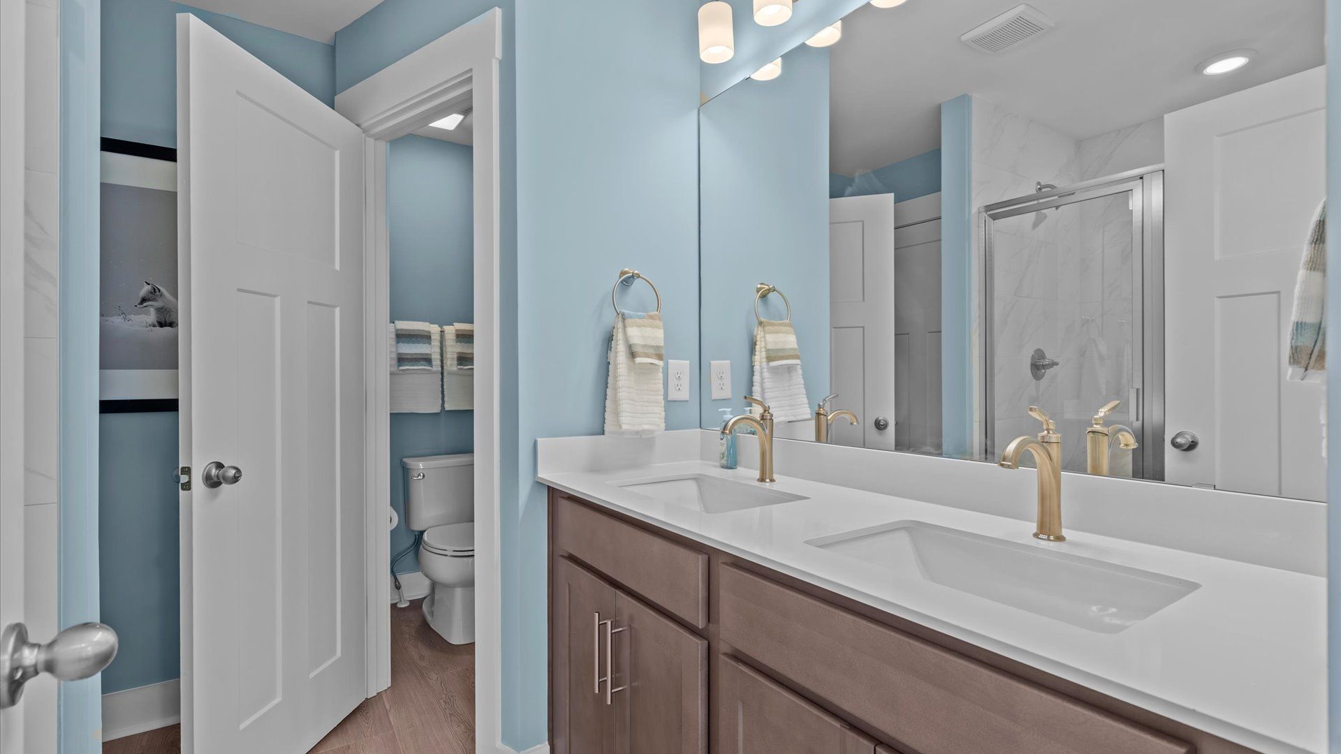 Notable primary bath featuring dual vanity, walk-in shower, and tasteful design touches throughout