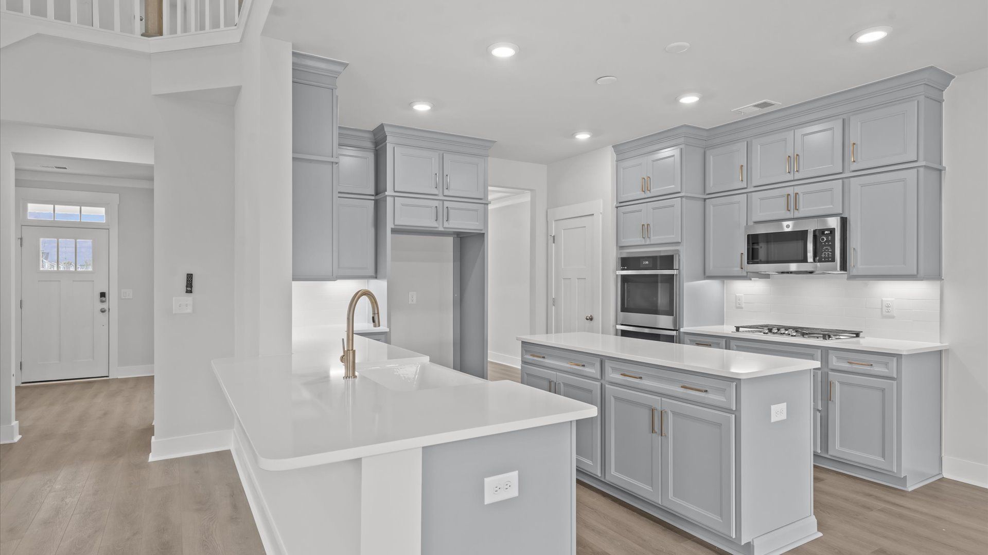 Modern kitchen with streamlined island for easy prep, storage, and gathering at Kayfield at Midway