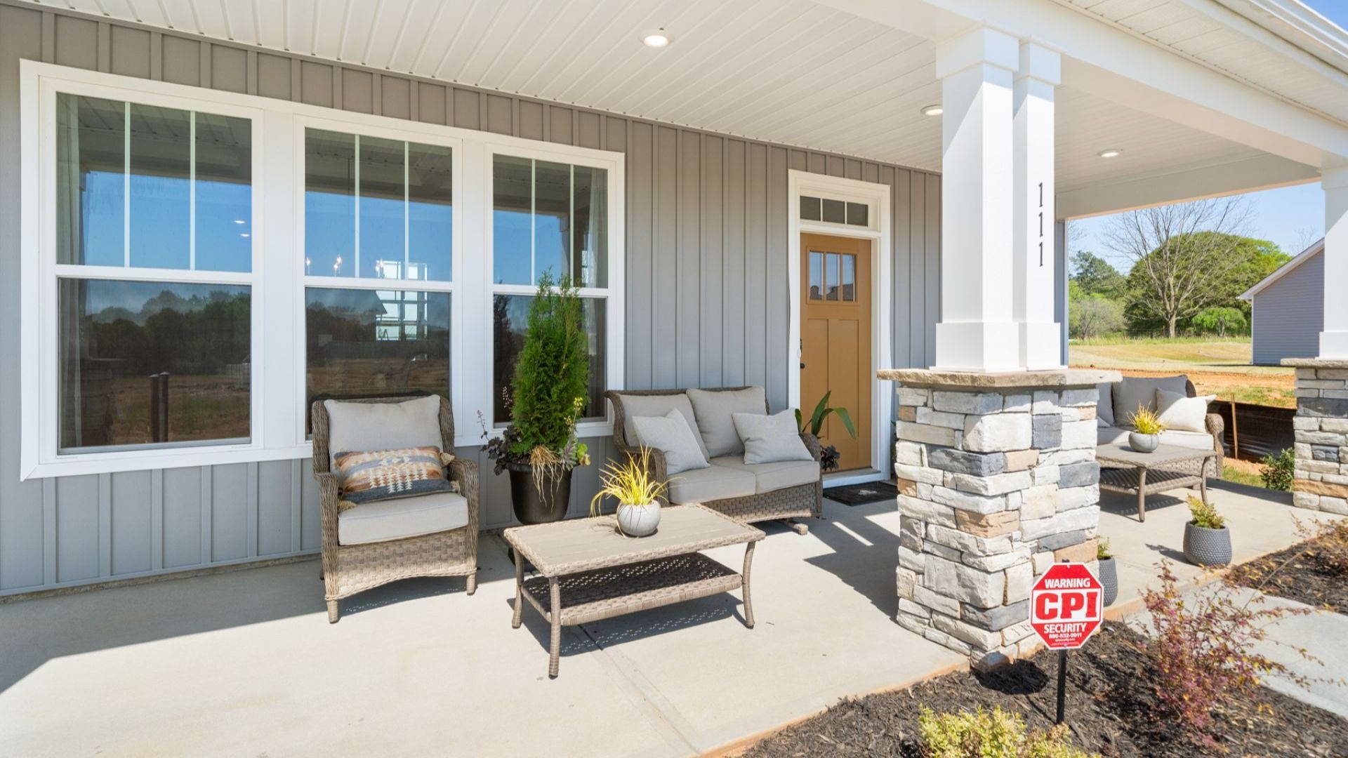 Elevated curb appeal with timeless stone accents and a welcoming covered entry at Wells Crossing