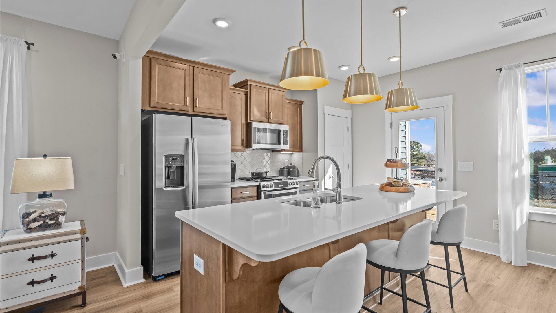 Kitchen with large island with white quartz countertops in two story townhome at Saluda Crossing by DRB Homes in Piedmont, SC