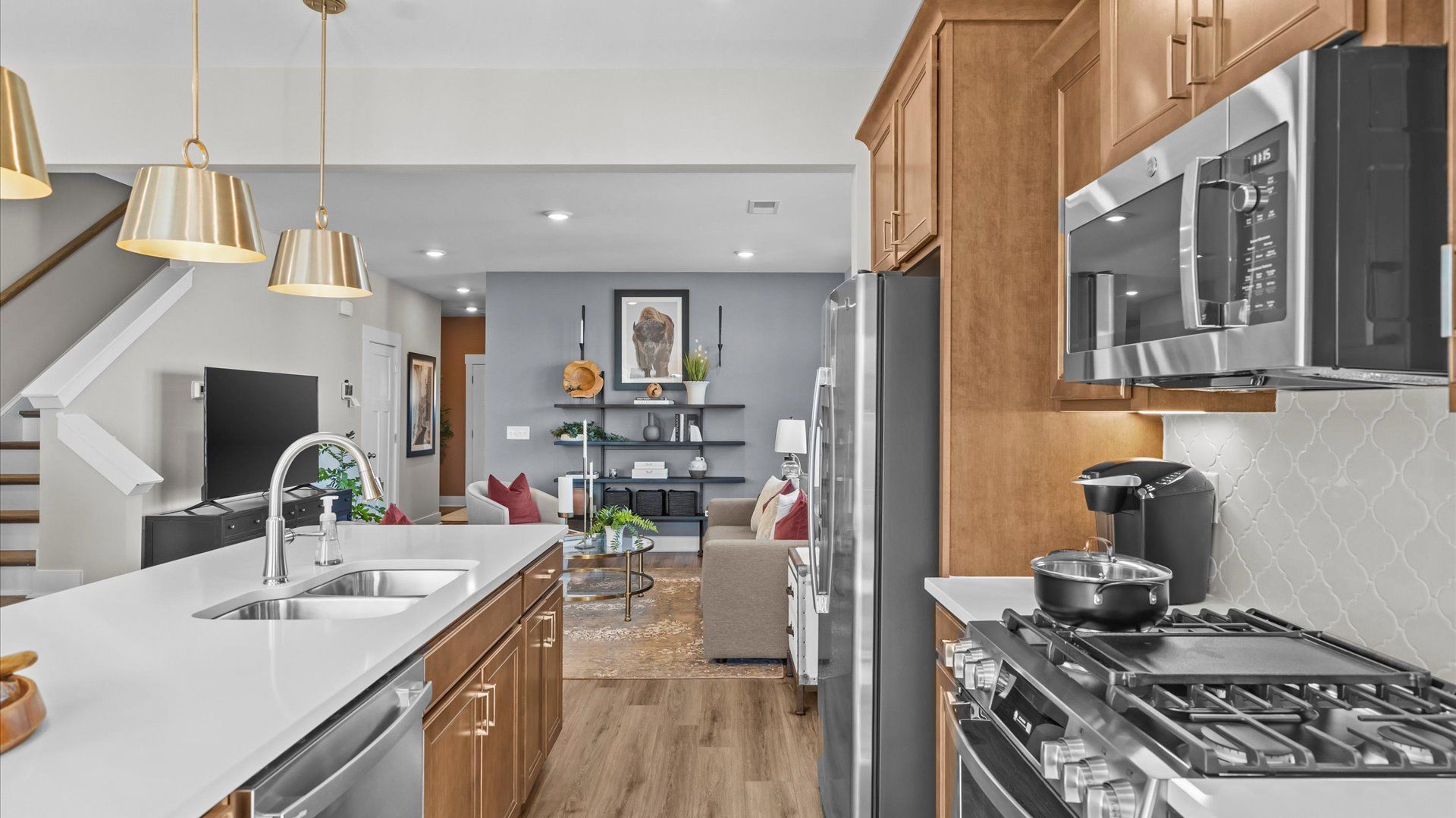 Quartz countertop kitchen with modern pendant lighting in two story townhome at Saluda Crossing by DRB Homes in Piedmont, SC