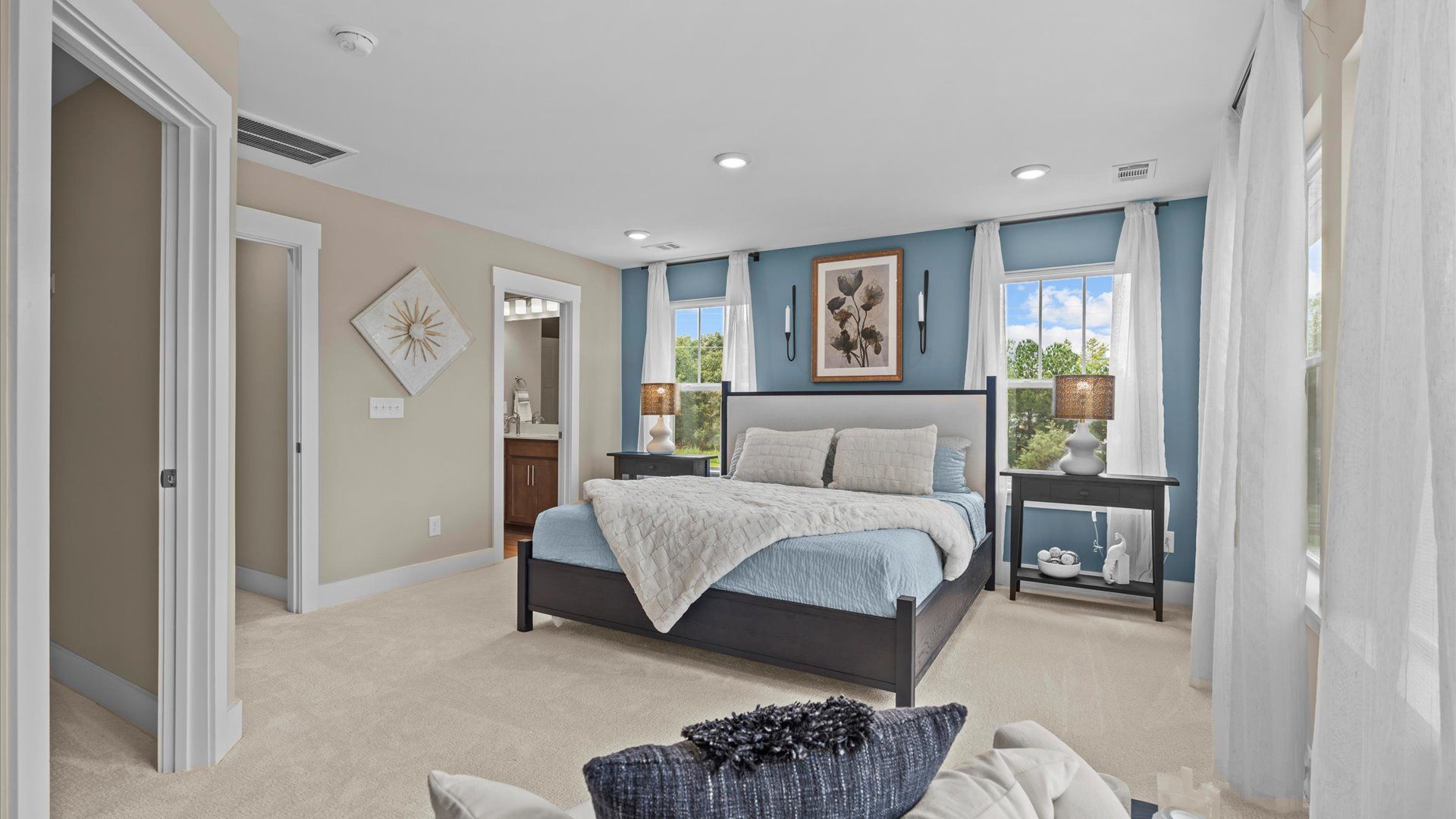 Serene primary suite with plush carpet and large windows in two story townhome at Saluda Crossing by DRB Homes