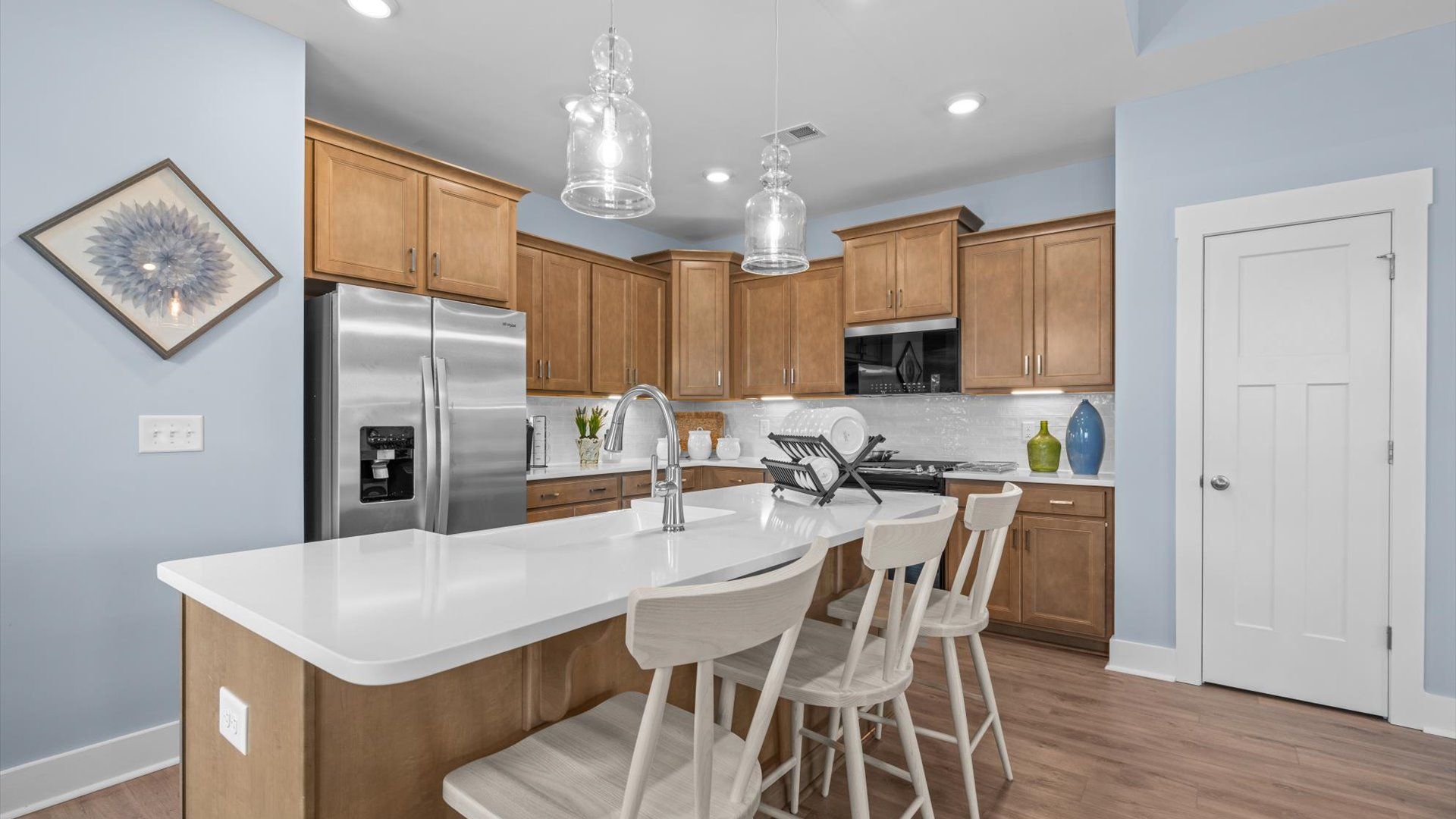 Accomplished kitchen design featuring pendant lighting above a statement island for both prep and gathering at Barton Hollow