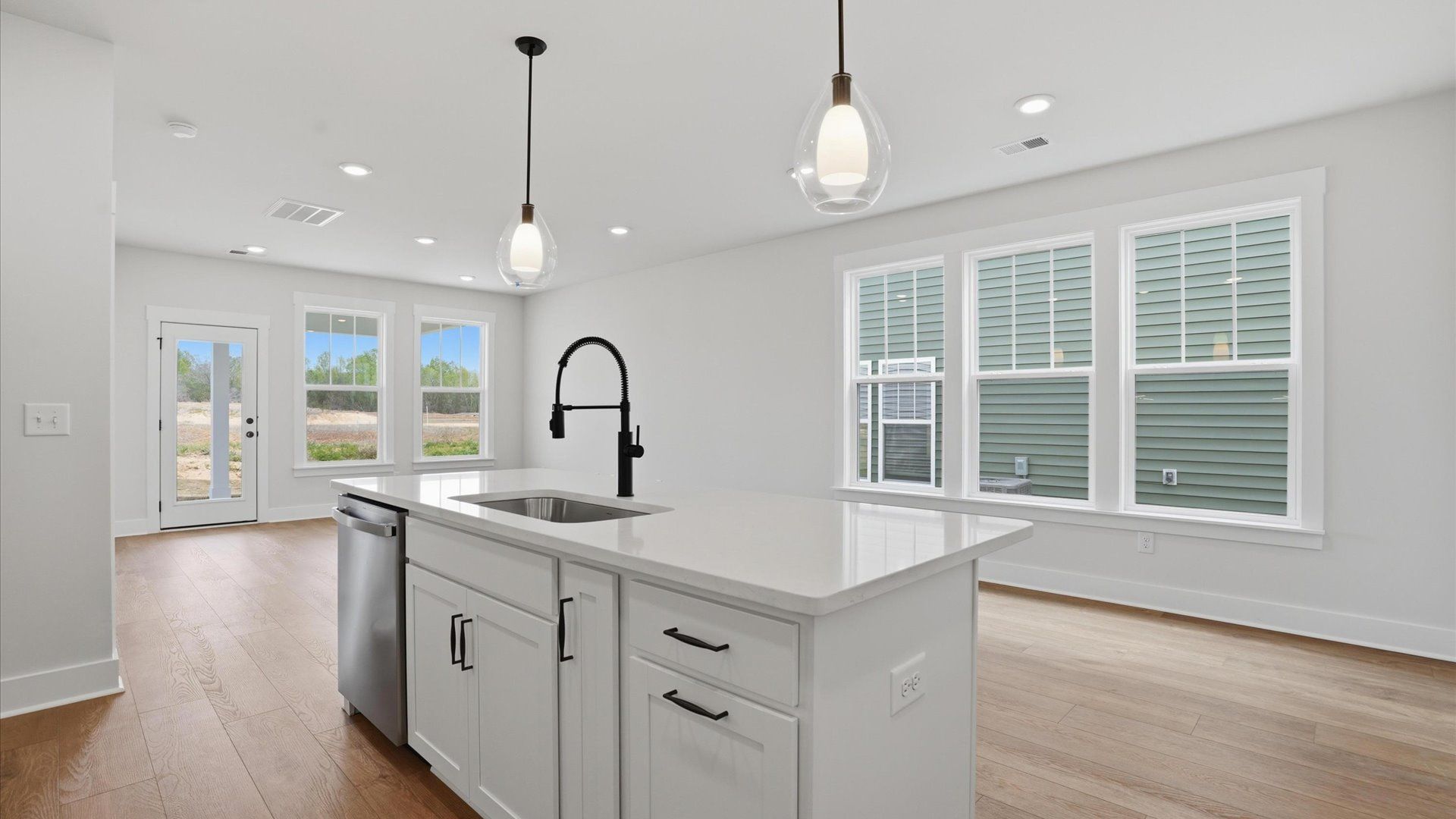 Highly skilled craftsmanship shines in this modern kitchen with pendant lighting and a central island focal point