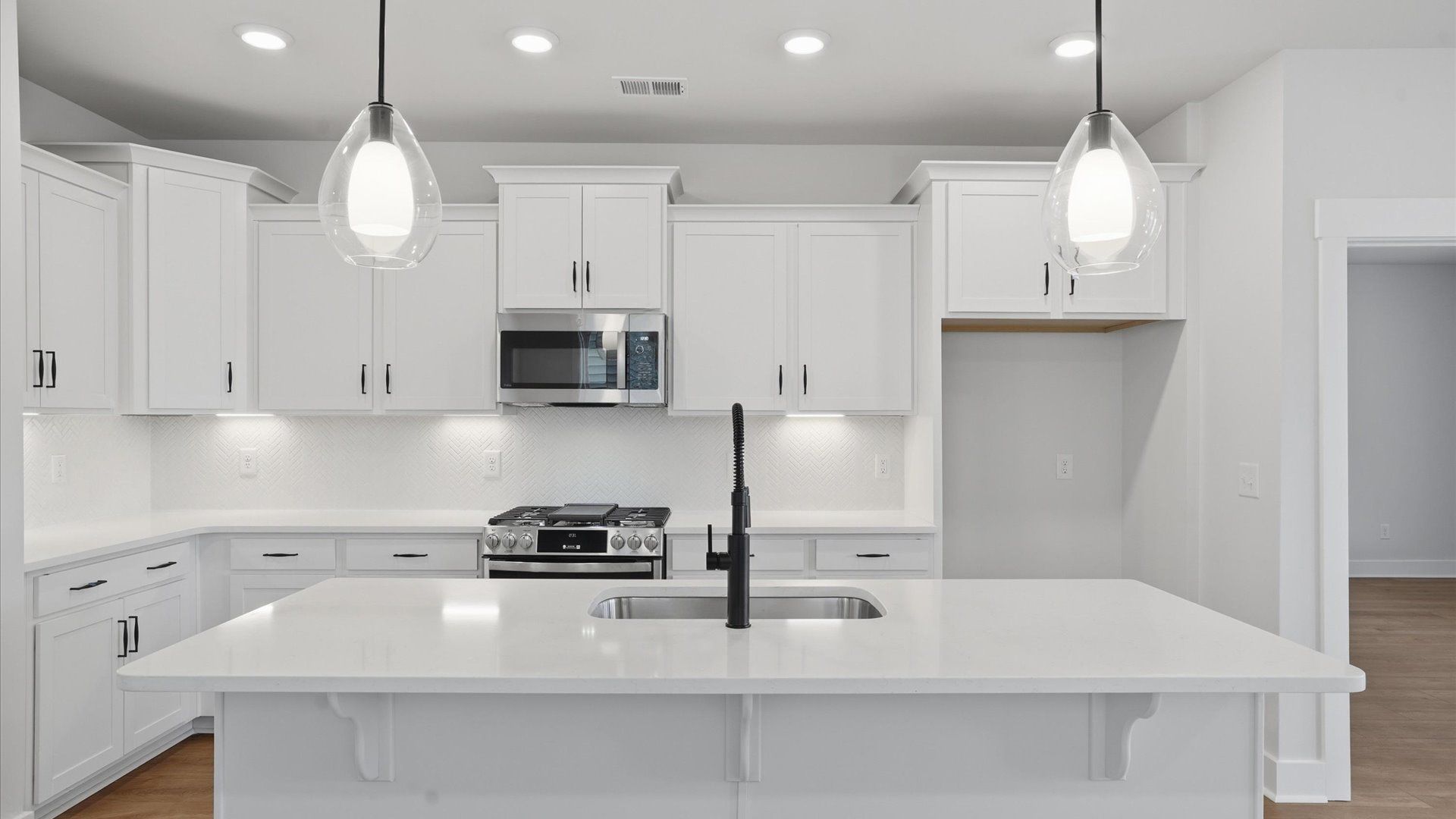Tasteful kitchen with oversized island and stylish pendant lighting—crafted to high standards located in Woodruff, SC