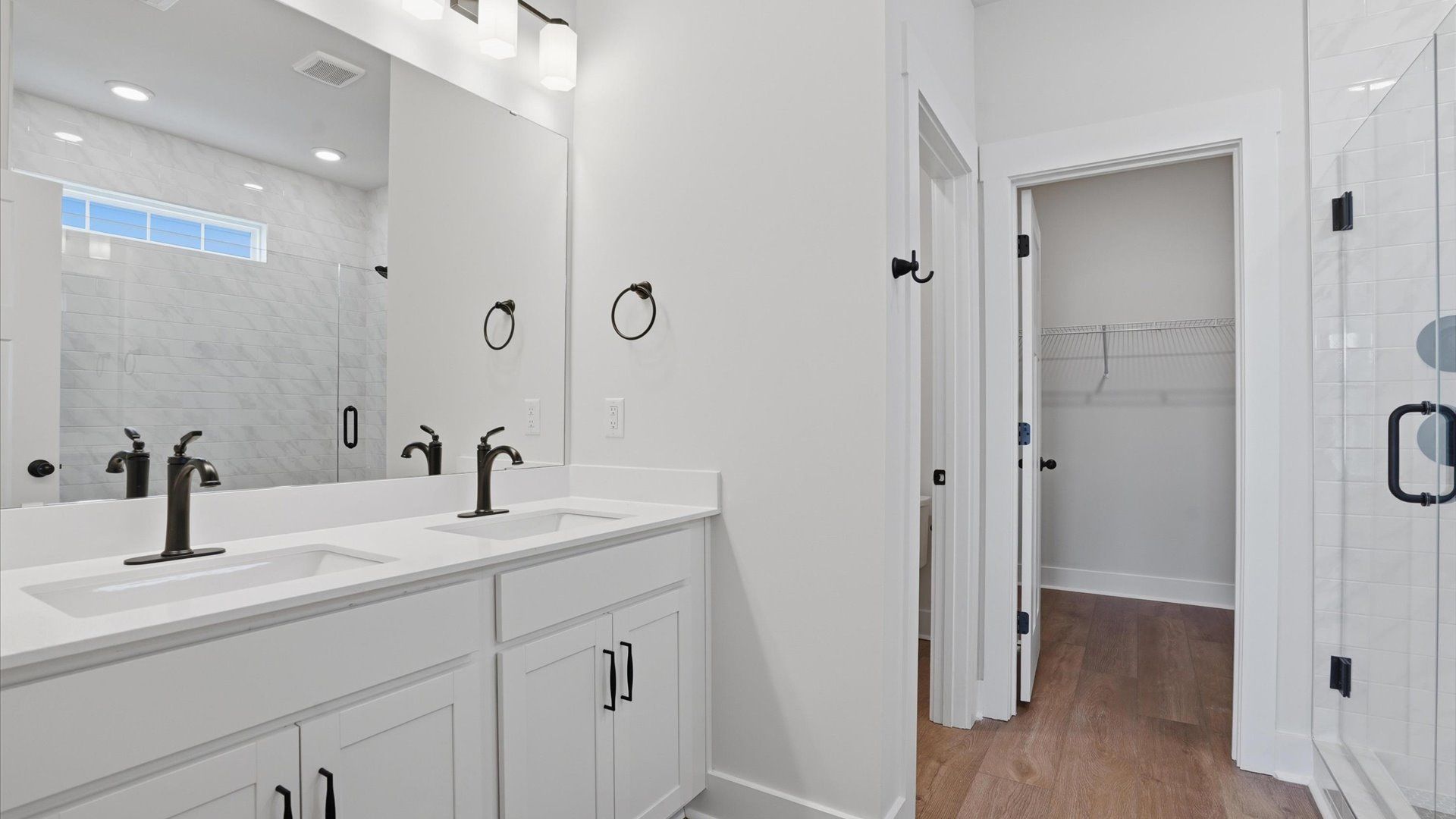Highly functional and elegant en-suite with dual vanities, tiled walk-in shower, and refined finishes in Woodruff, SC