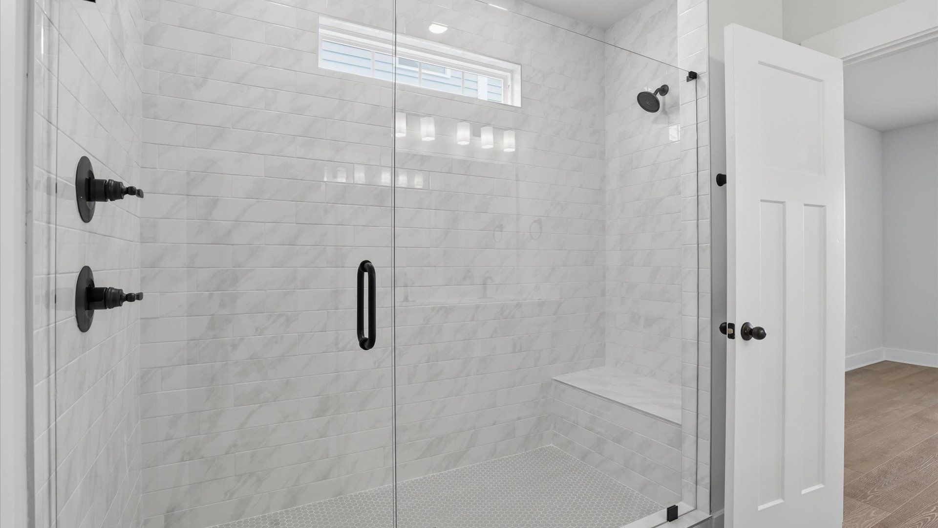 Memorable mornings begin in this elegant primary bathroom with walk-in shower and double vanity