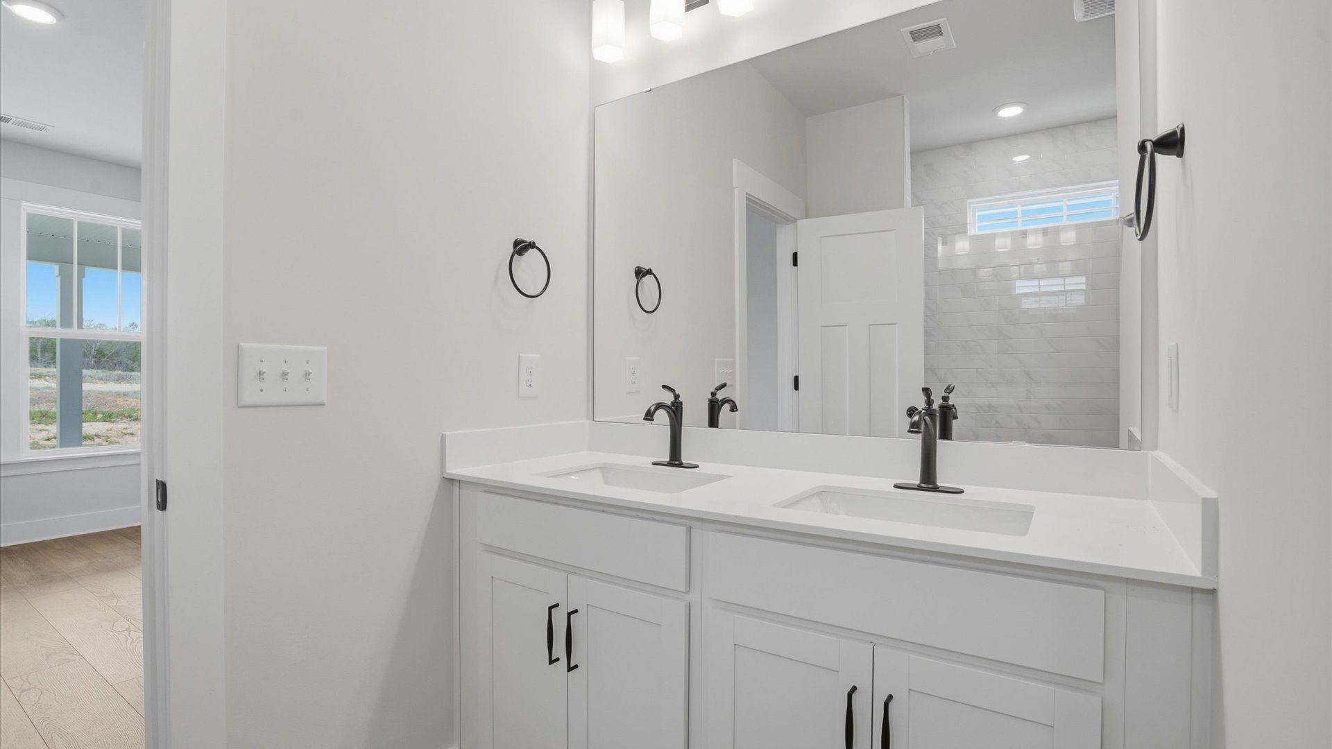 Accomplished design shines in this primary bath with dual vanity and a sleek walk-in shower