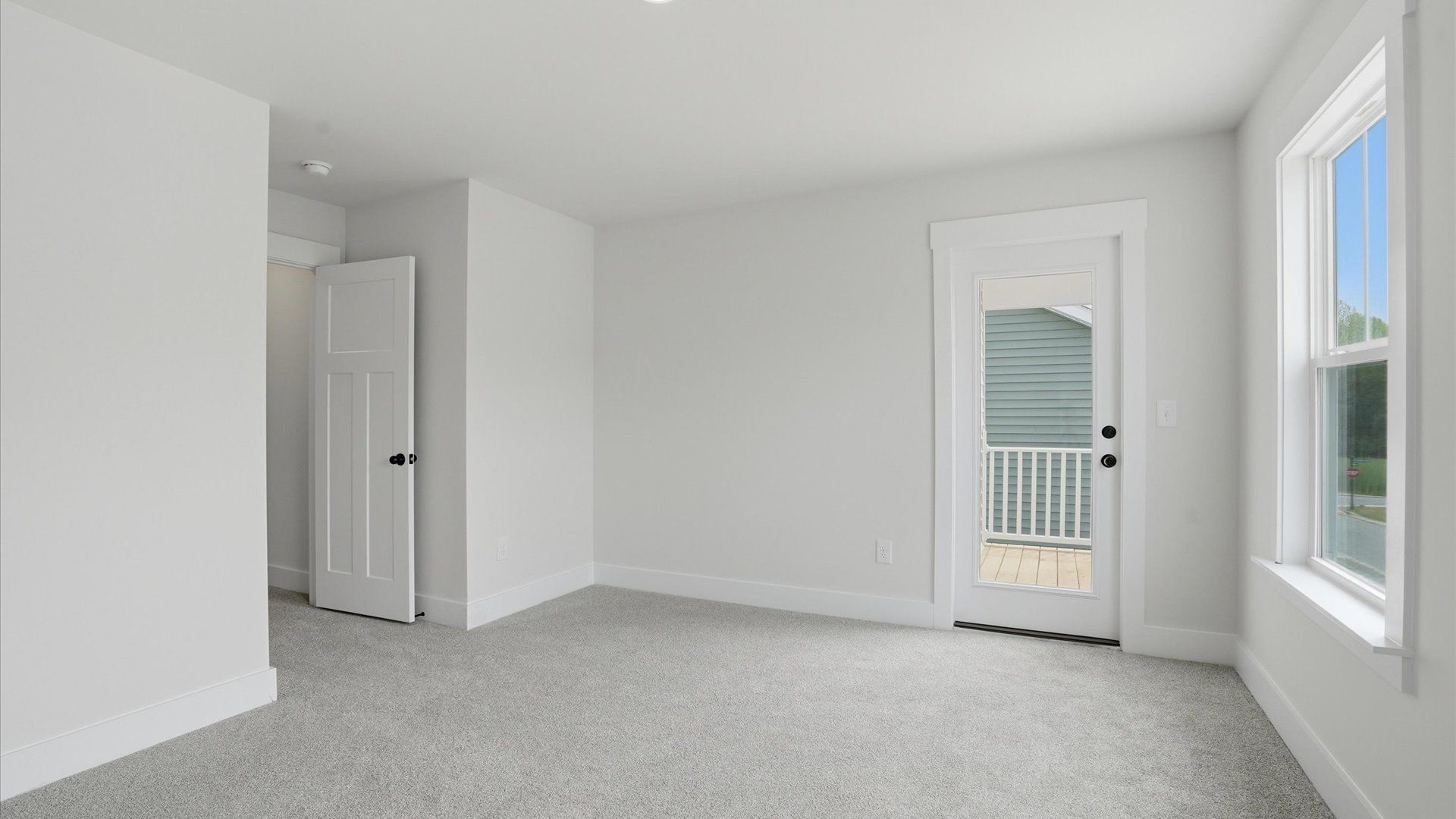 Elegant bedroom retreat featuring soft carpet and oversized windows that create a bright, welcoming space at Harrier Point