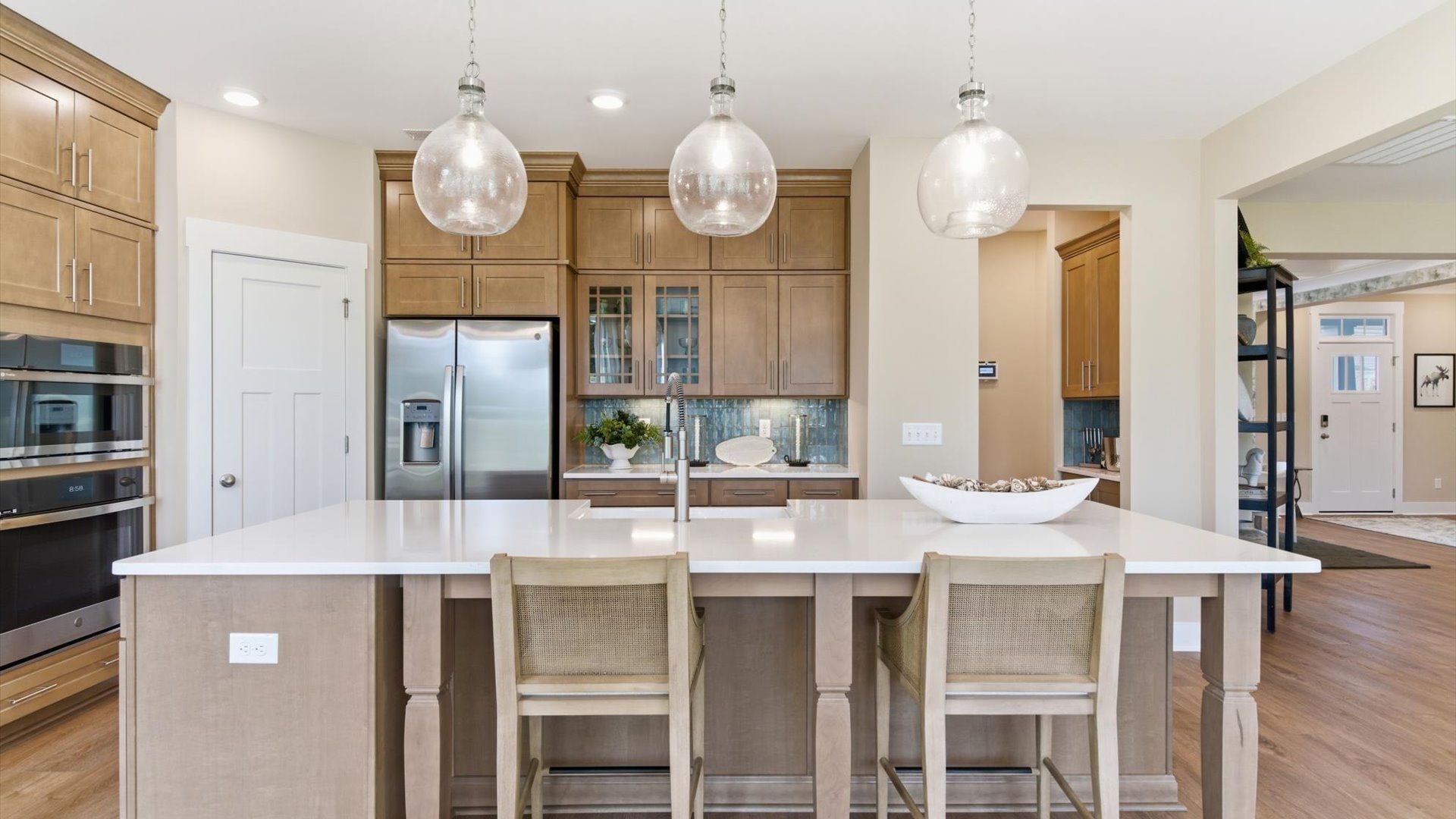 Superior kitchen with quartz countertops, pendant lighting, and a generously sized island at a highly sought-after community