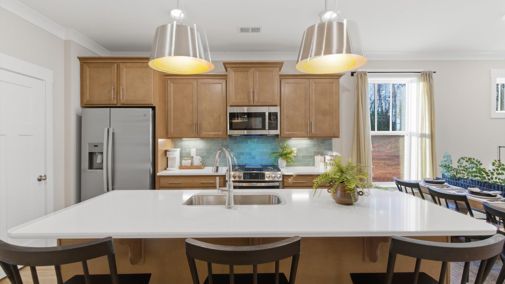 Elegant kitchen with large island and pendant lighting in this first-class DRB Homes design at Pelham Crossing