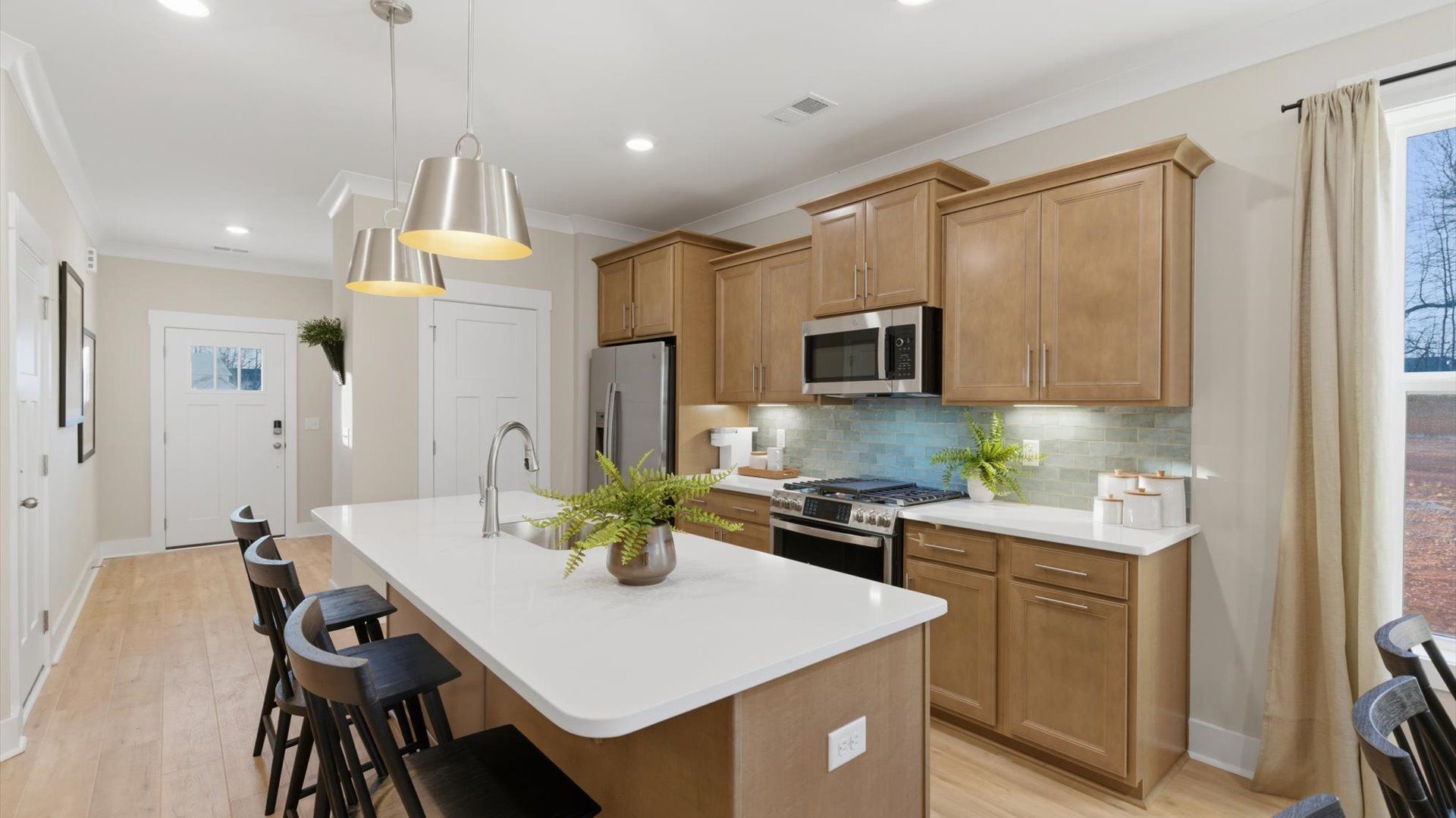 Vibrant and open kitchen centered around a 9-foot island with elegant pendant lighting above located in Greenville, SC