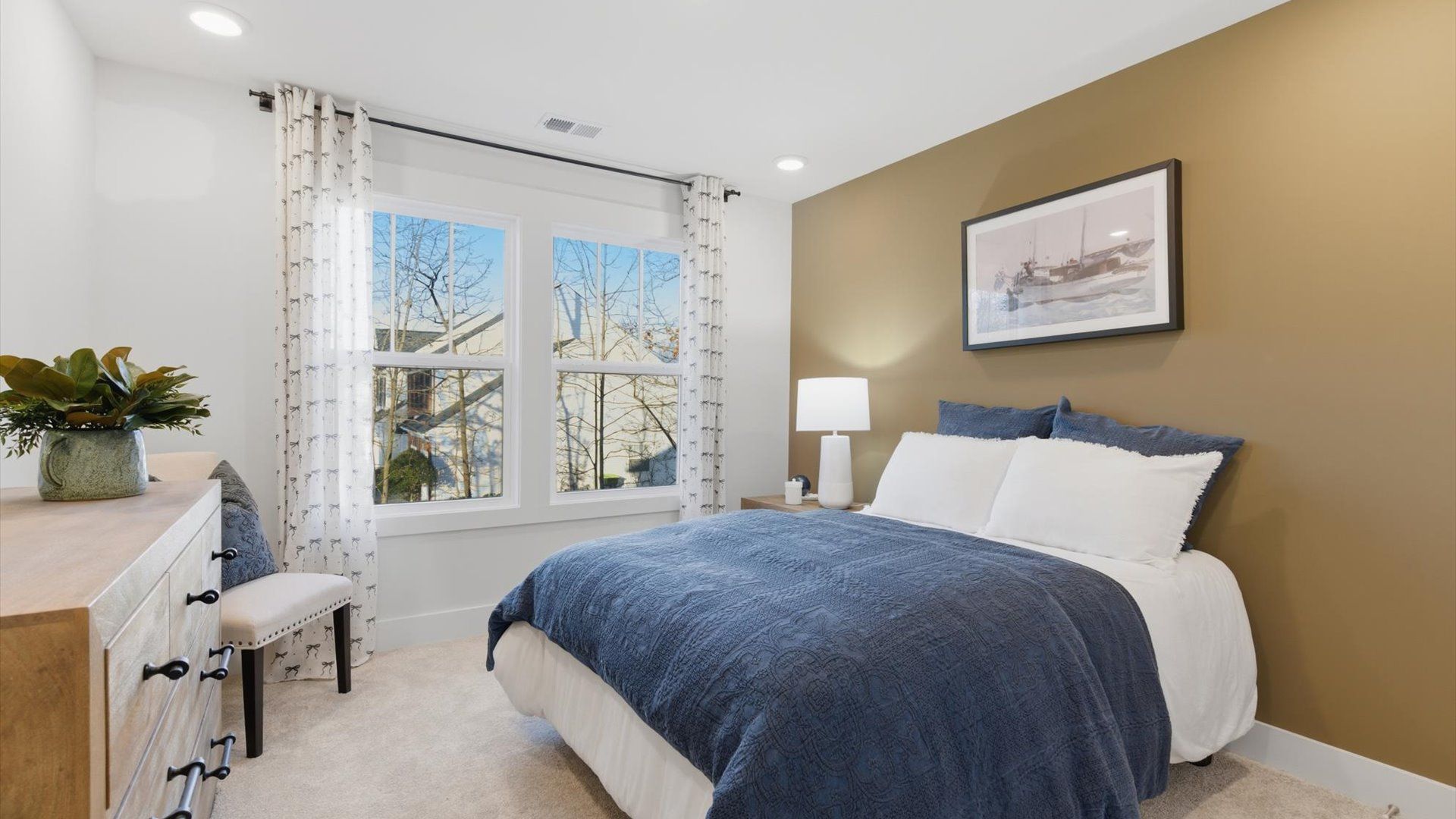 Highly functional bedroom with large windows, carpeted flooring, and tasteful finishes throughout