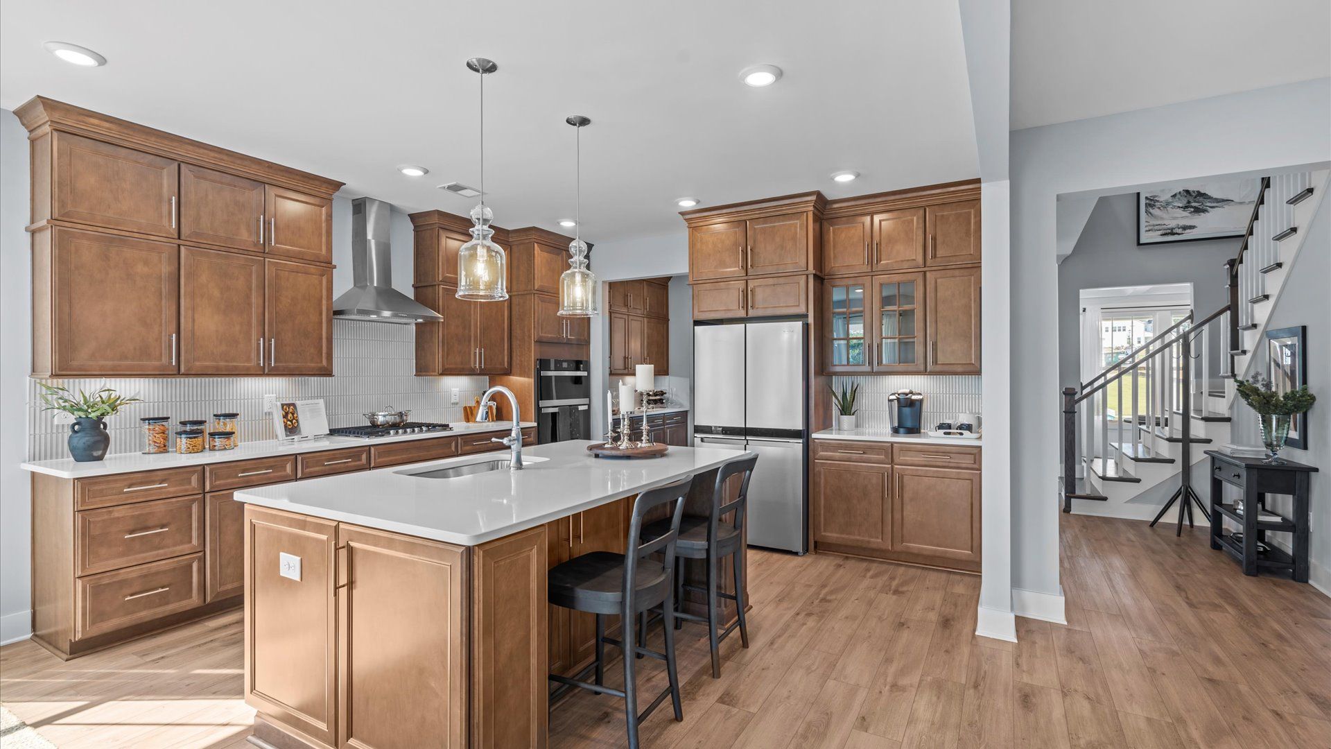 Tasteful design meets functional luxury in this kitchen with a statement island and modern pendant lighting