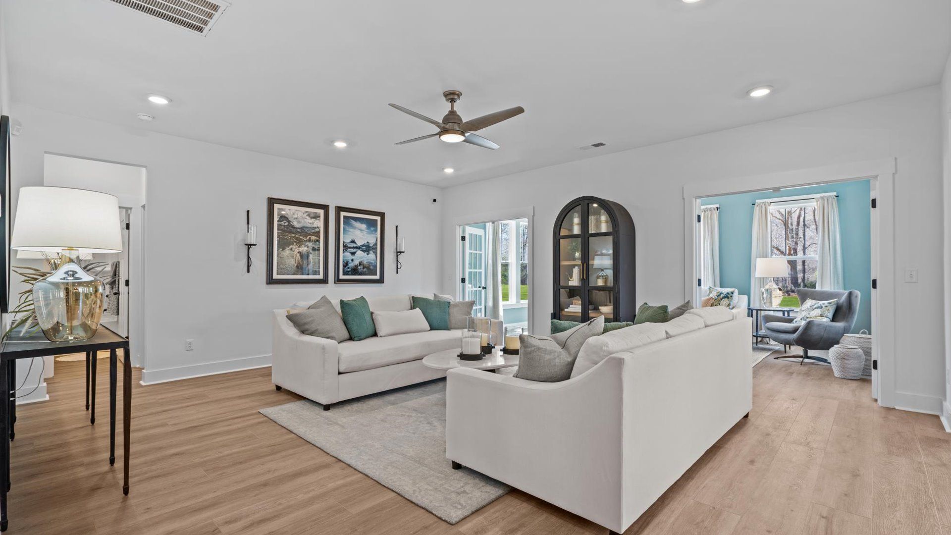 Elegant family room featuring hardwood flooring, large windows, and thoughtful architectural detail